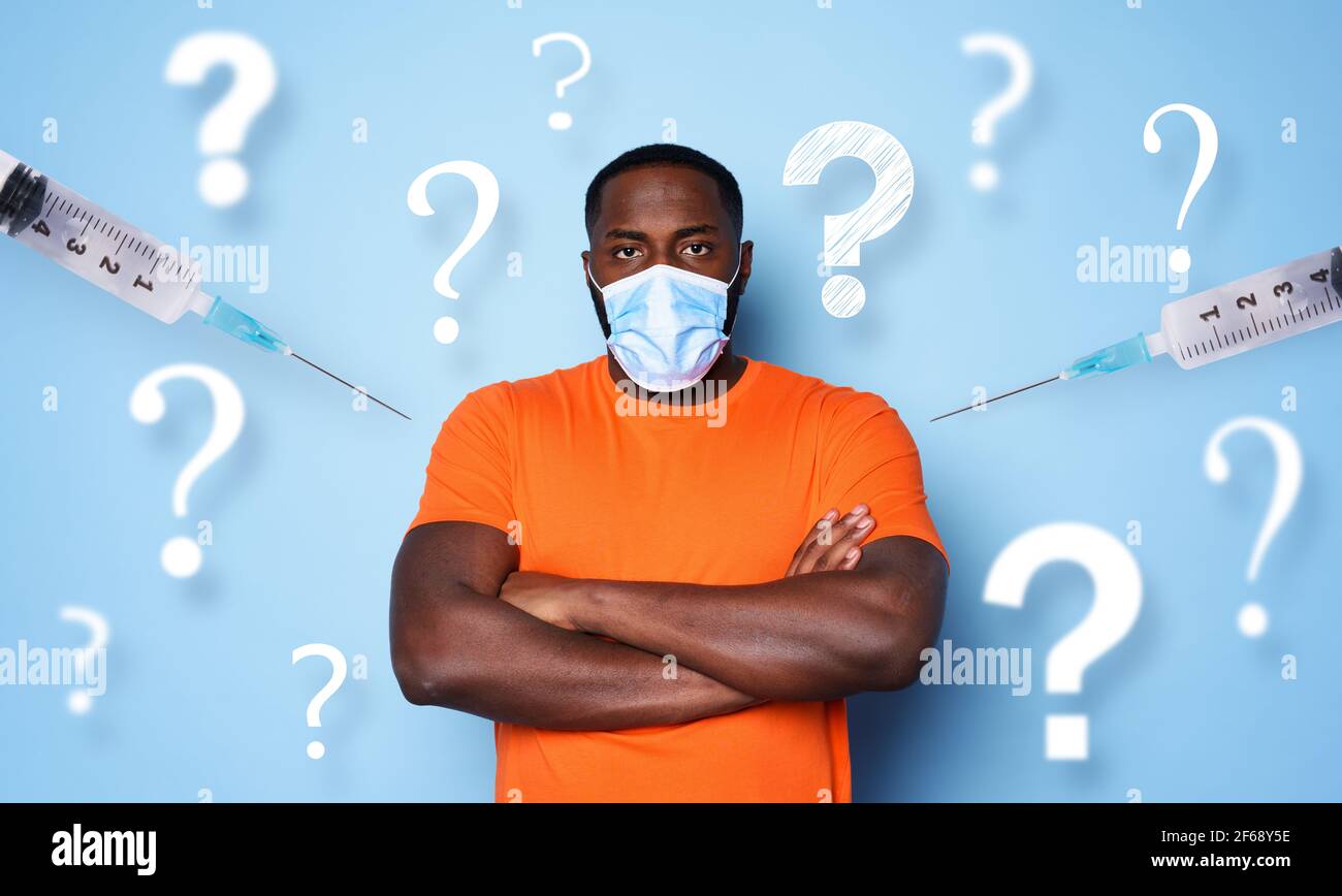 Man with face mask has a lot of questions and doubts about covid 19 vaccine. cyan background Stock Photo