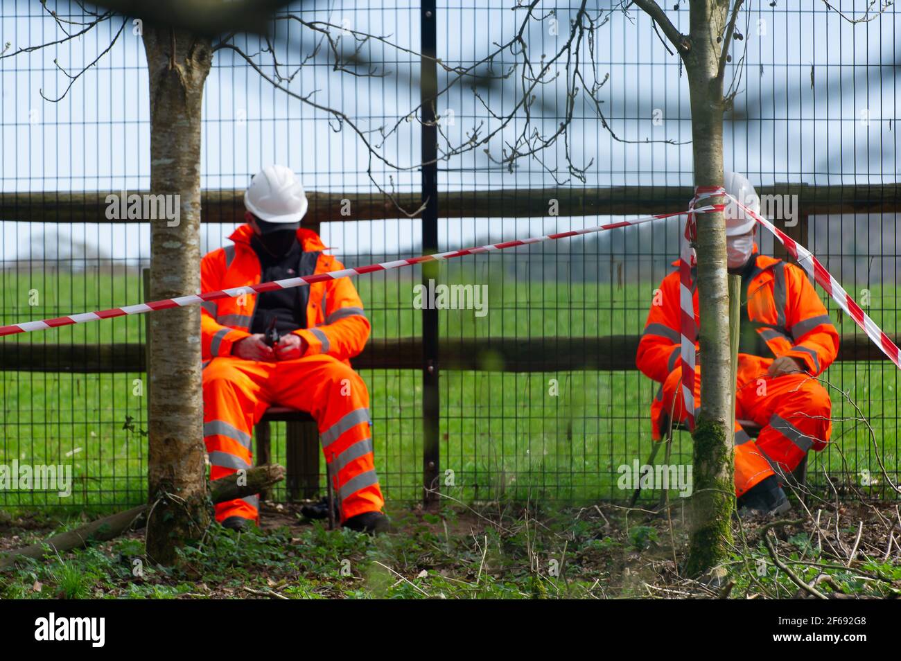 Aylesbury Vale, Buckinghamshire, UK. 30th March, 2021. HS2 Security Guards are paid to sleep in chairs guarding woodlands. HS2 have taken over Road Barn Farm and tree fellers were chainsawing trees today with great glee. They were also using a tree grabber to rip trees out of the ground during the bird nesting season and allegedly without a bat licence. HS2 have put up temporary traffic lights on the A413 whilst they carry out their destruction of the countryside and are causing long tailbacks annoying motorists. The High Speed 2 rail link from London to Birmingham is carving a huge scar acros Stock Photo