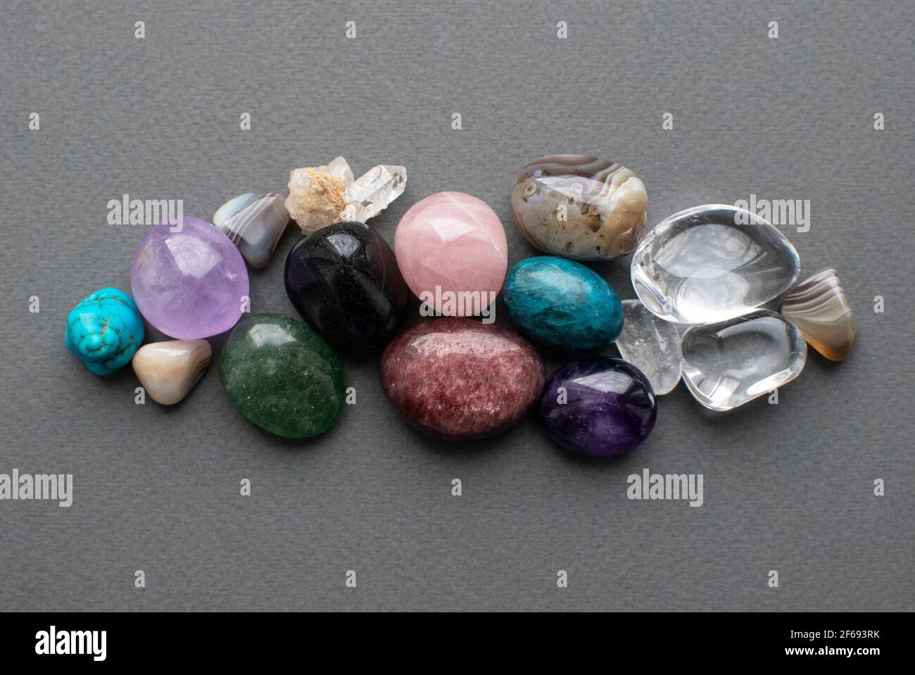 Tumbled gems of various colors. Amethyst, rose quartz, agate, apatite, aventurine, rock crystal, turquoise. Stock Photo