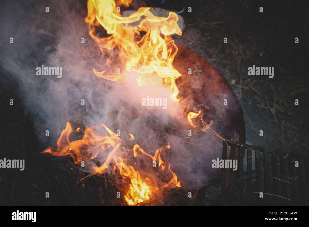 Smoke and Flames rise from a metal Campfire ring Stock Photo - Alamy