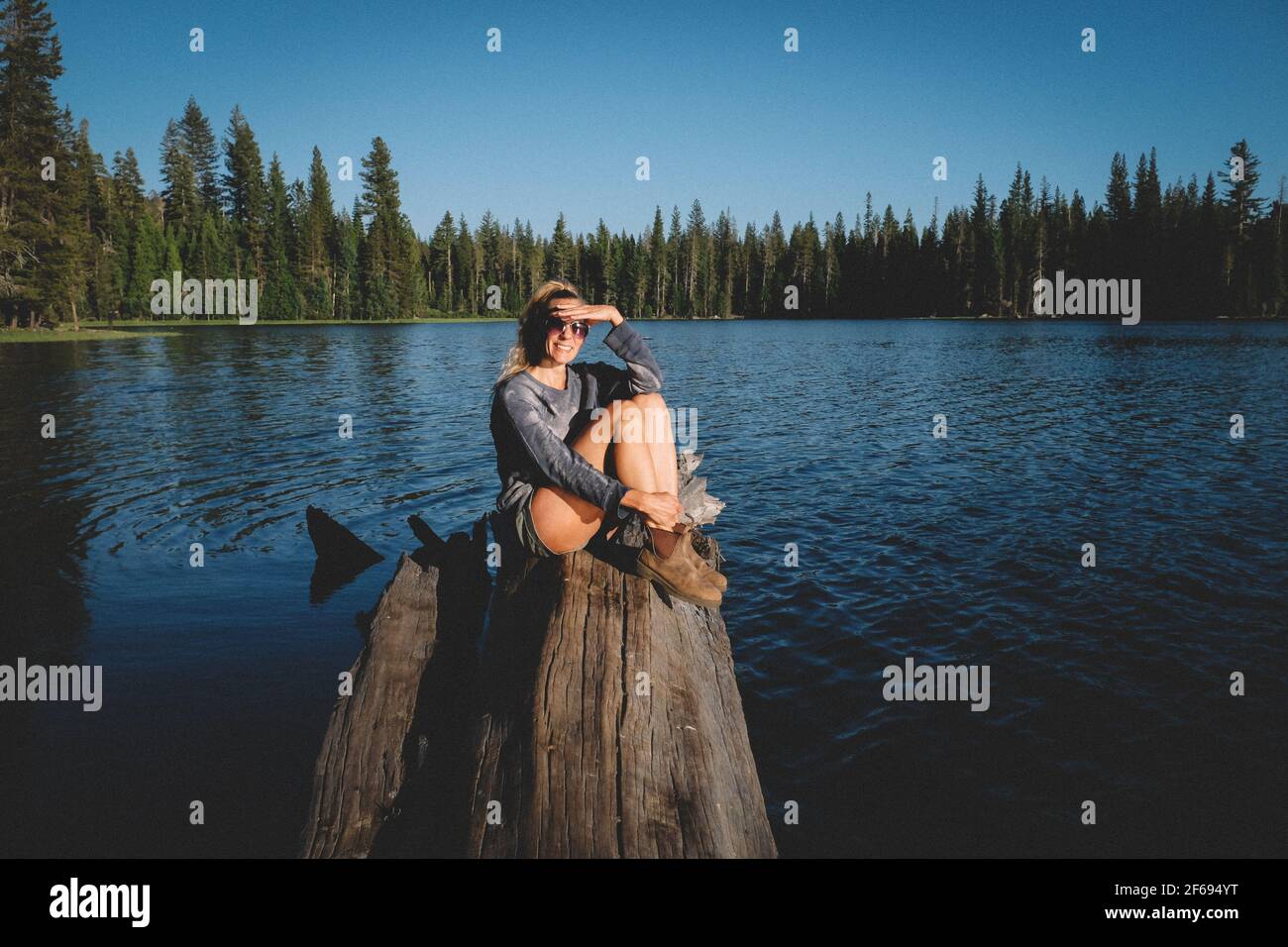 Blonde Woman on Sierra Lake Shields her Eyes from the Sun Stock Photo