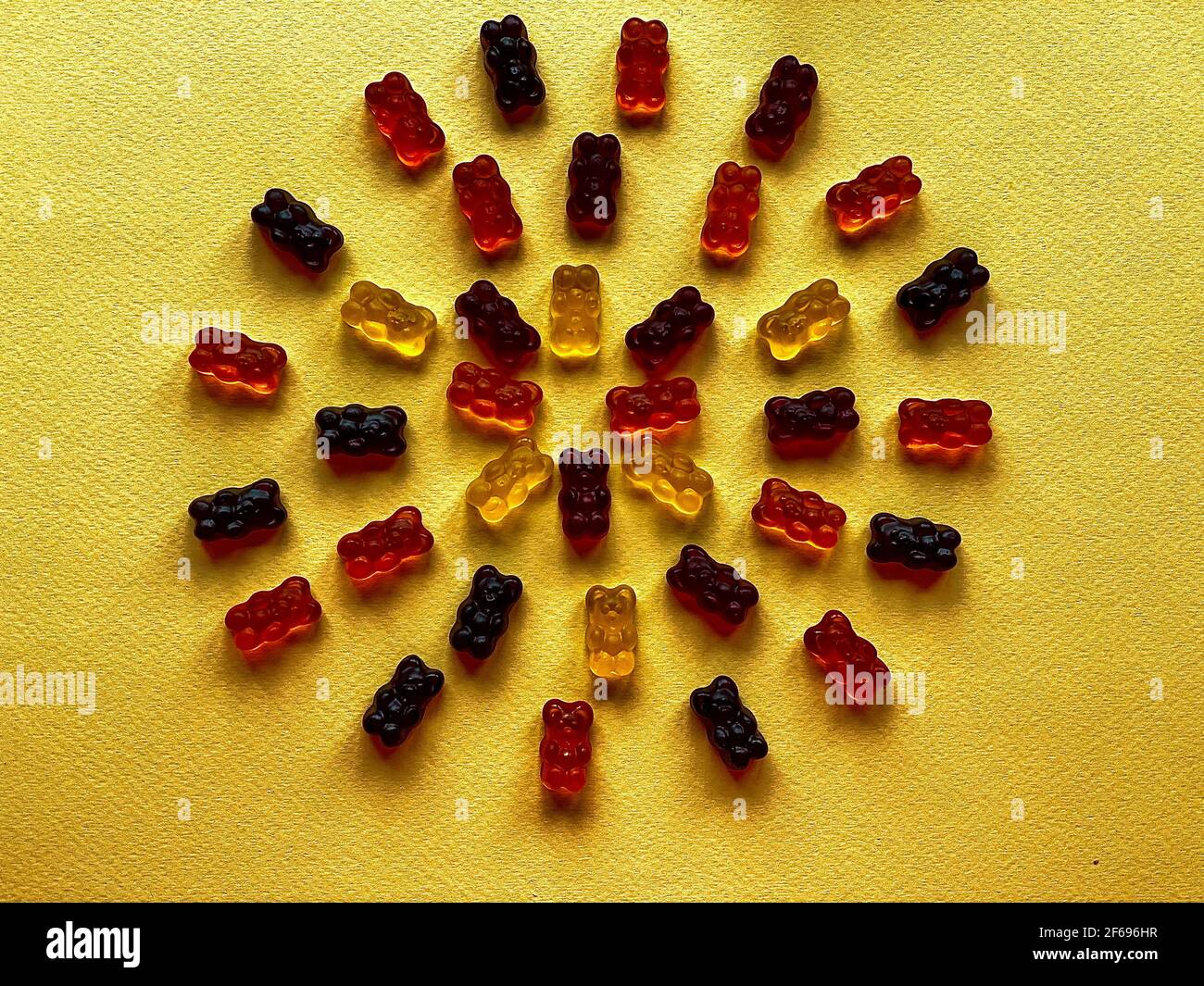 beautifully laid out gummy bears on a yellow background Stock Photo