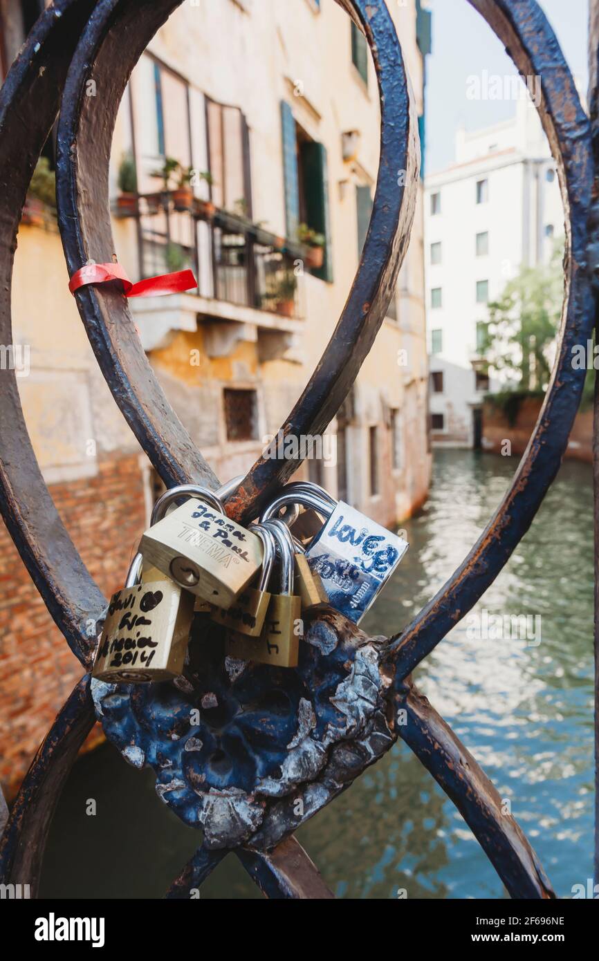 Padlocks attached to railings on bridge above venetian canal Stock Photo