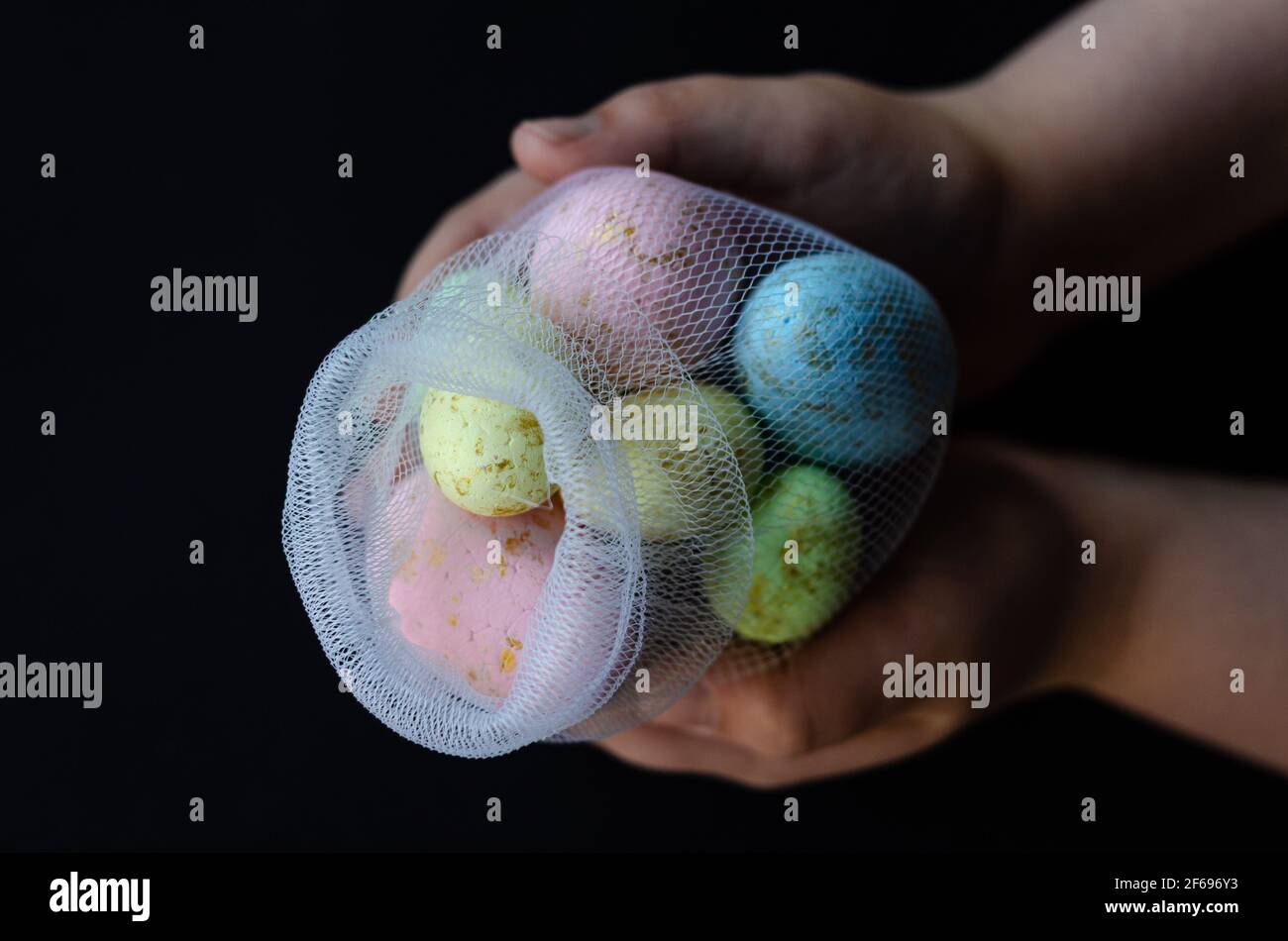 Easter colored eggs in a net, in hand, free space Stock Photo