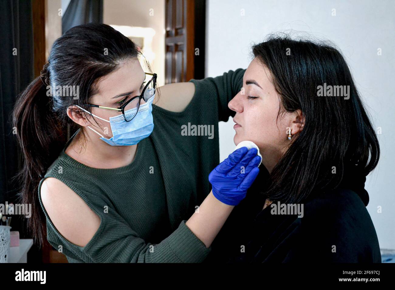 beauty artist doing makeup to woman in beauty salon Stock Photo