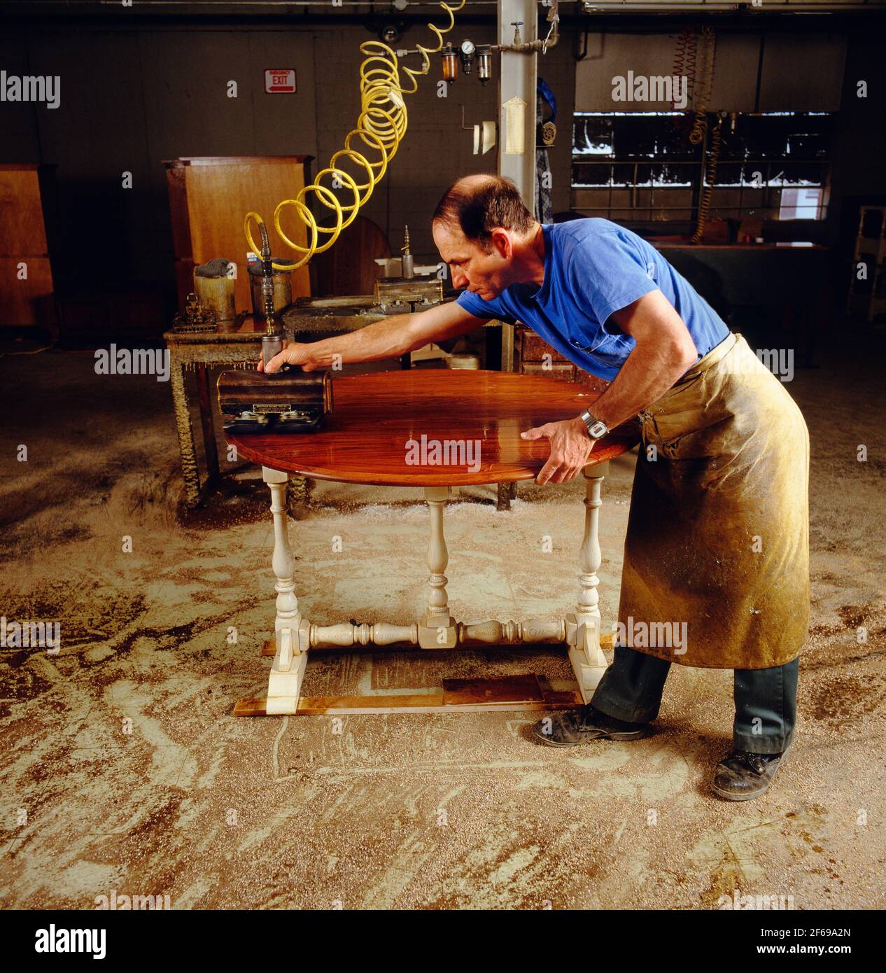 WORKER DOES THE FINAL POLISHING TO A PIECE OF FURNITURE, PENNSYLVANIA