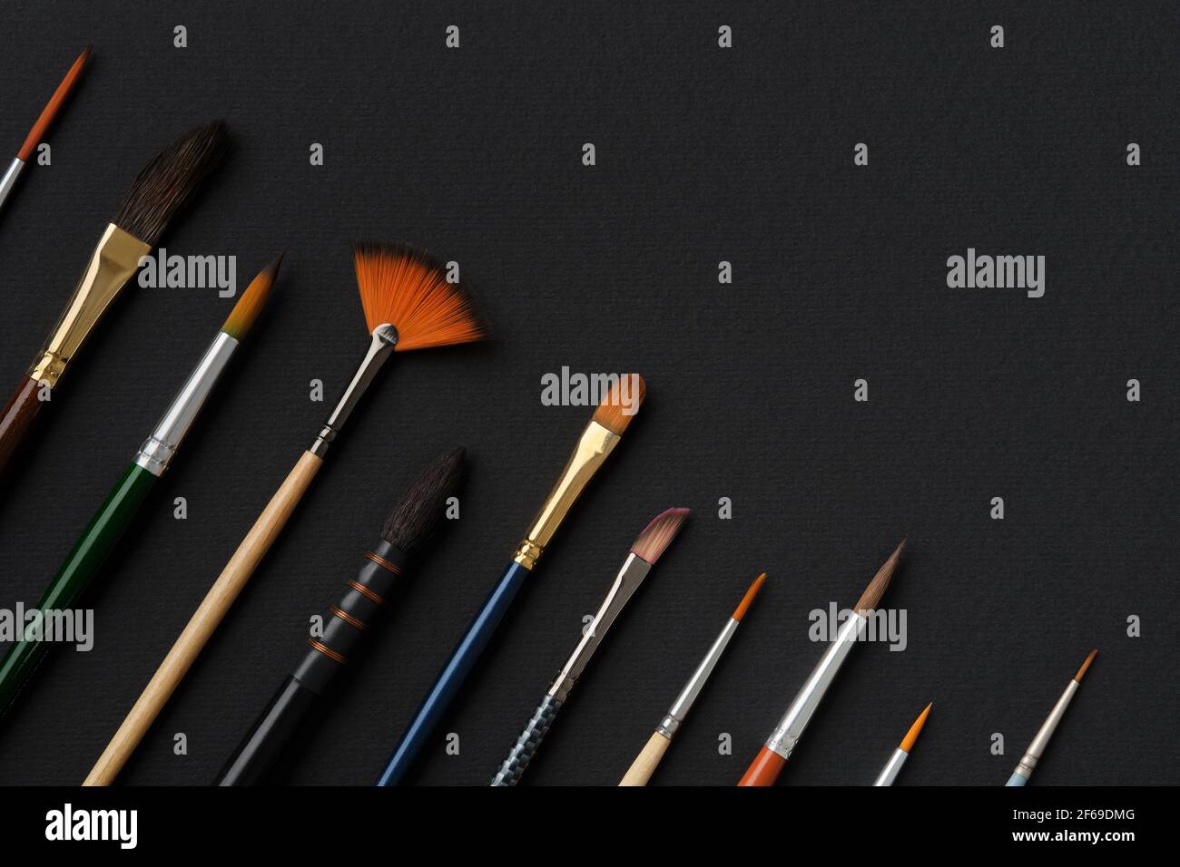 Paintbrushes for watercolor painting. top view, flat lay. Different shape and size paint brushes on black paper sheet. Set of brushes for watercolor, Stock Photo