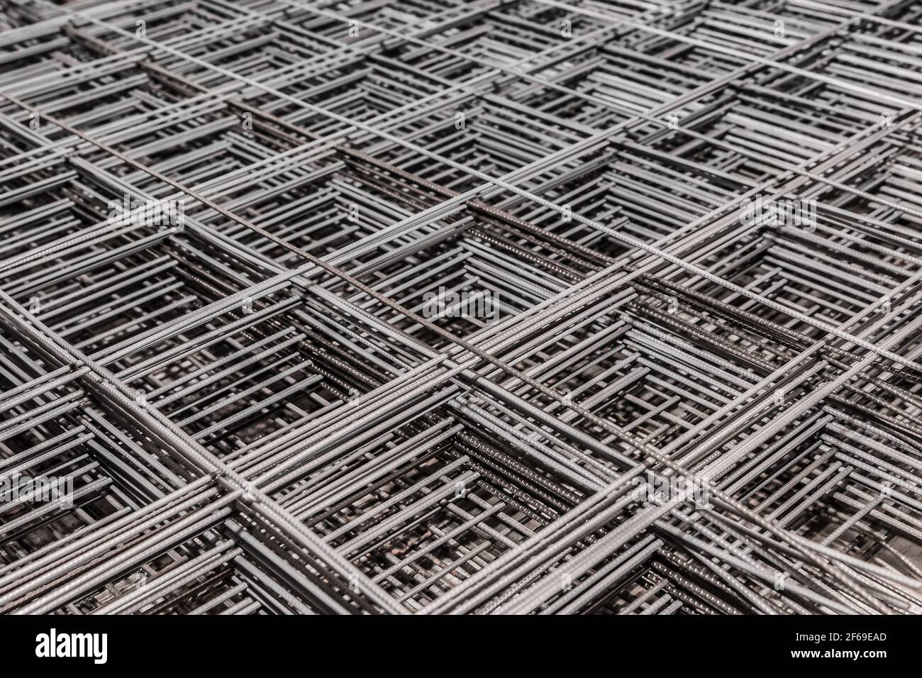Metal bars background in diagonal lines close-up, industrial mesh of steel wire texture, building material. Stock Photo