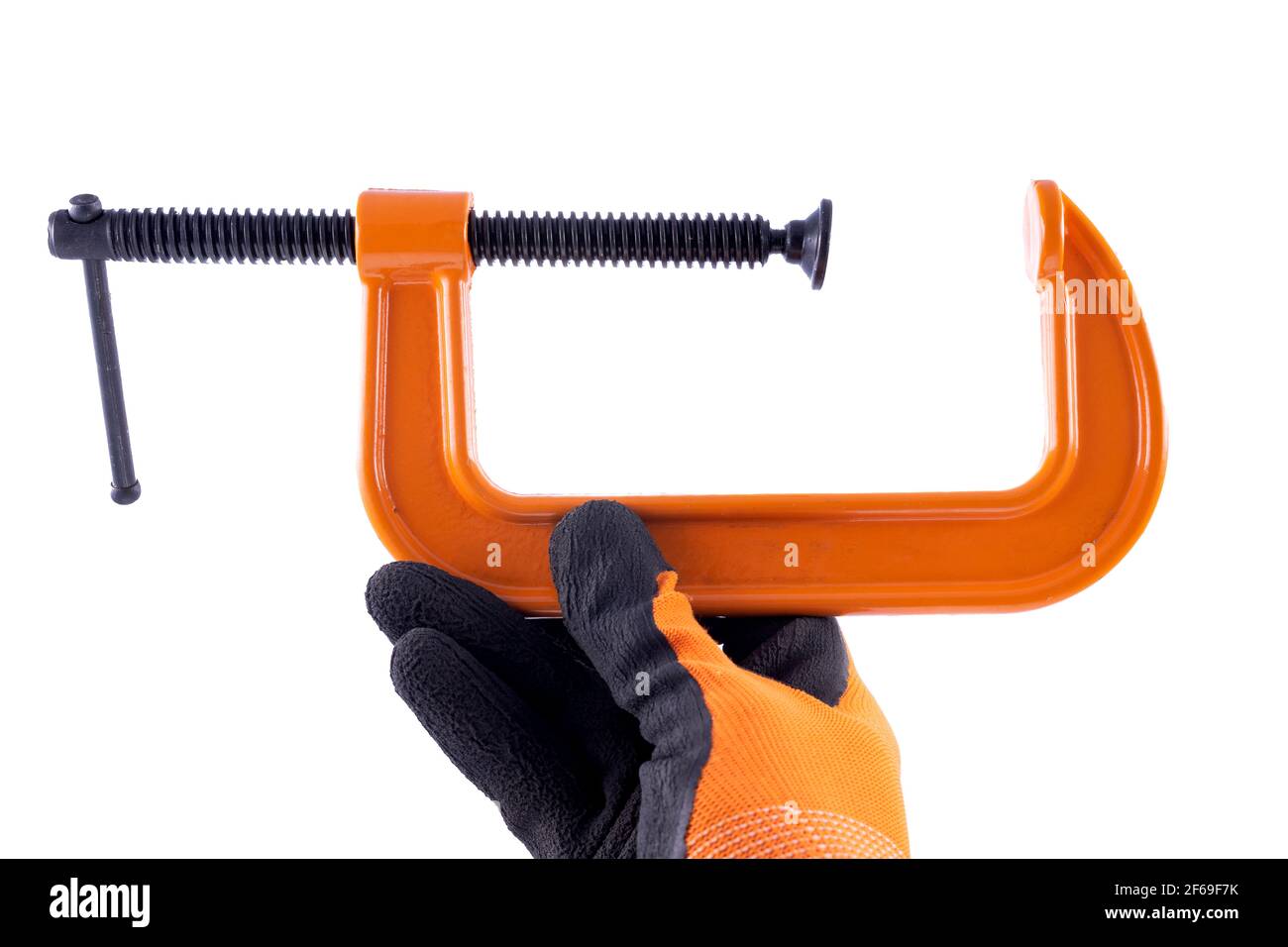 A grip in the hand of a carpenter. Accessories for gluing in a gloved hand. Light background. Stock Photo