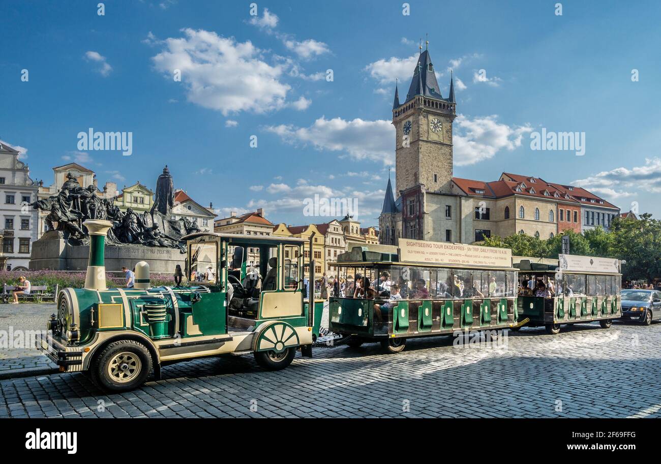 sightseeing train at the Old Prague Town Square against the backdrop of the stone tower of the Old Town Hall, Capital City of Prague, Czech Republic Stock Photo