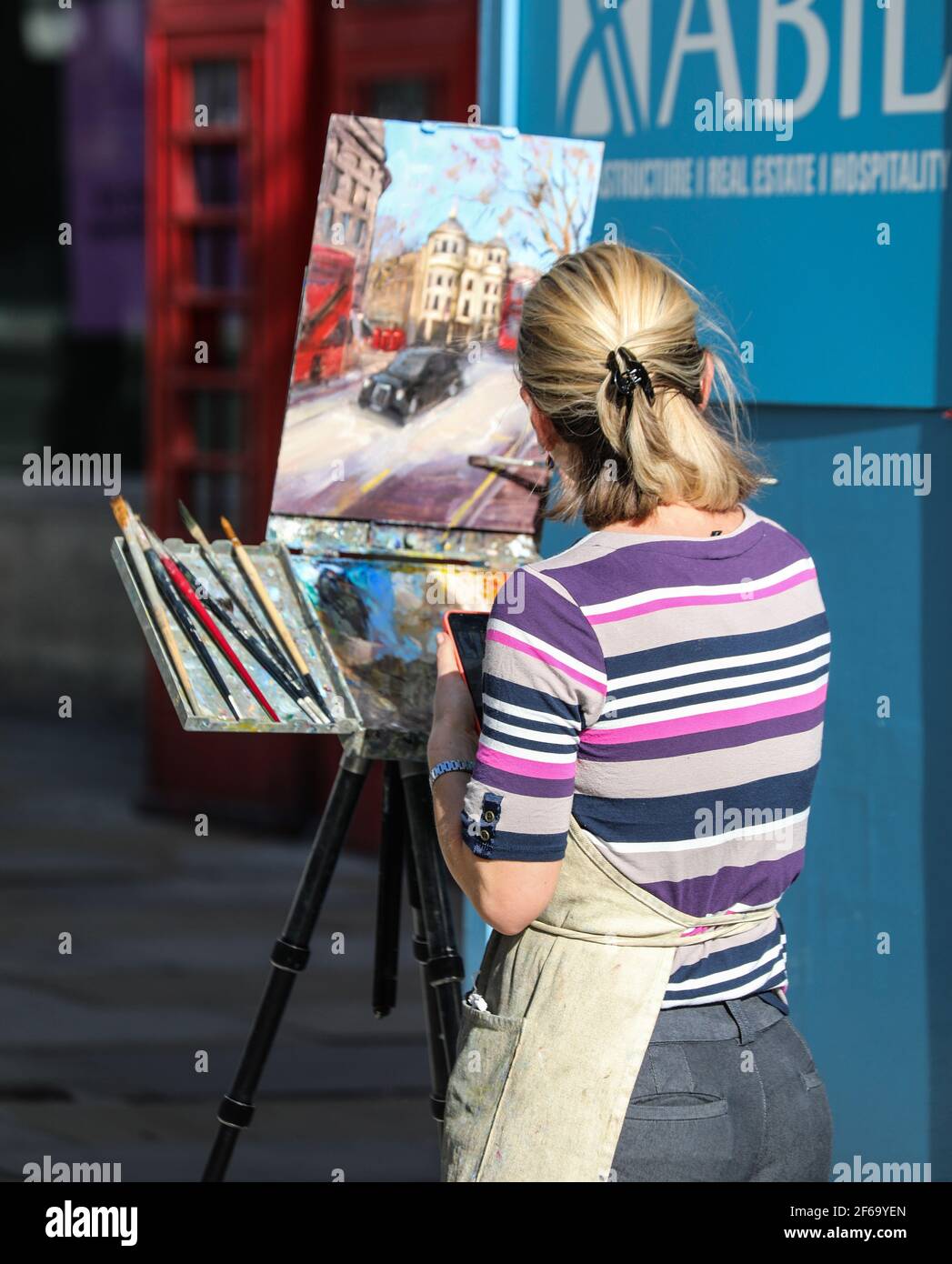 a-woman-seen-painting-a-picture-as-she-enjoys-the-sunshine-on-the