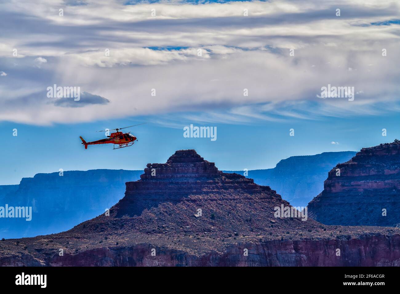 A Tourist Helicopter Hovering over a rock in Grand Canyon National Park Stock Photo