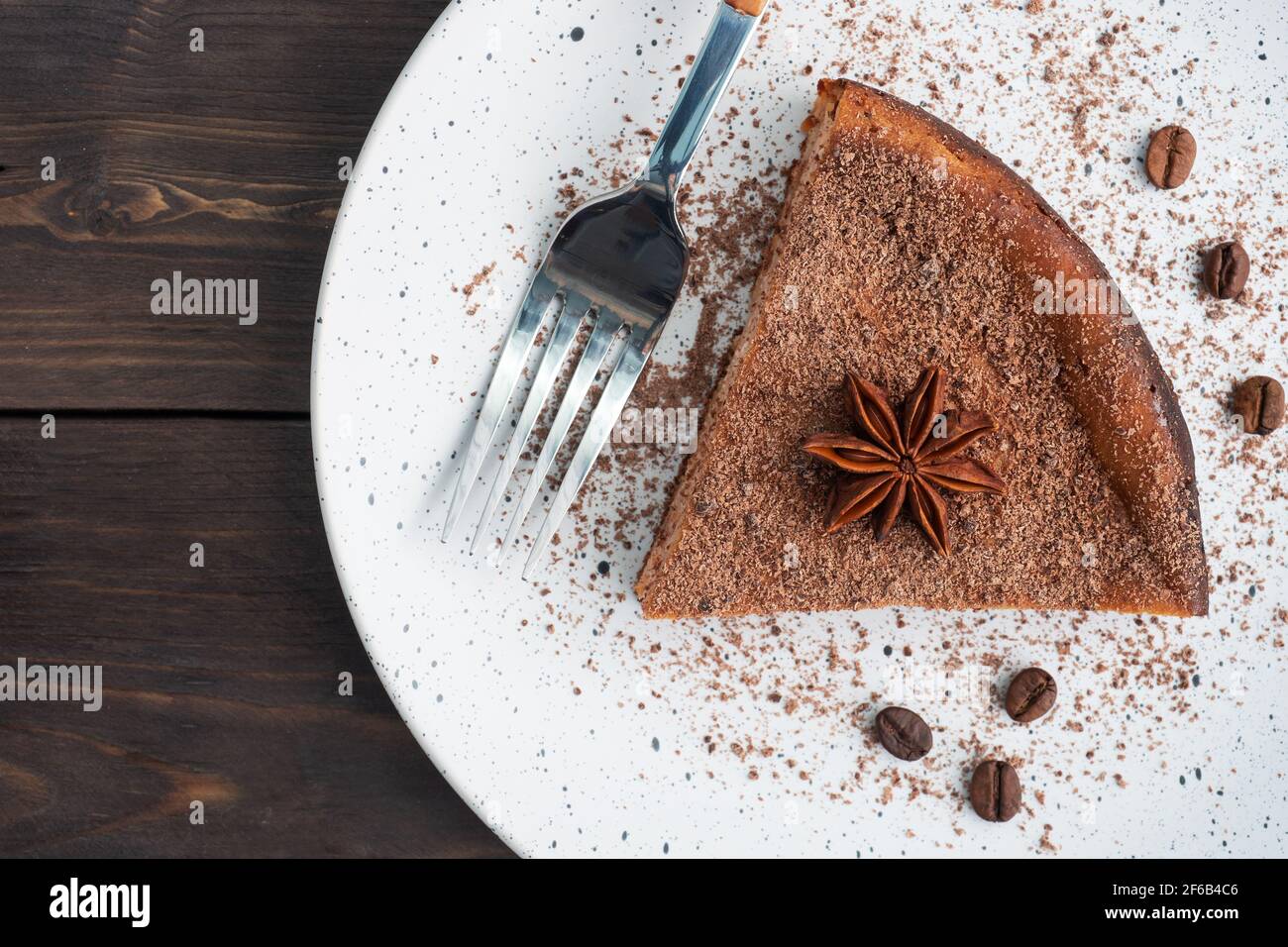Slice of chocolate curd casserole on a plate, a portion piece of cake with chocolate and coffee. Dark wooden rustic background top view, copy space Stock Photo