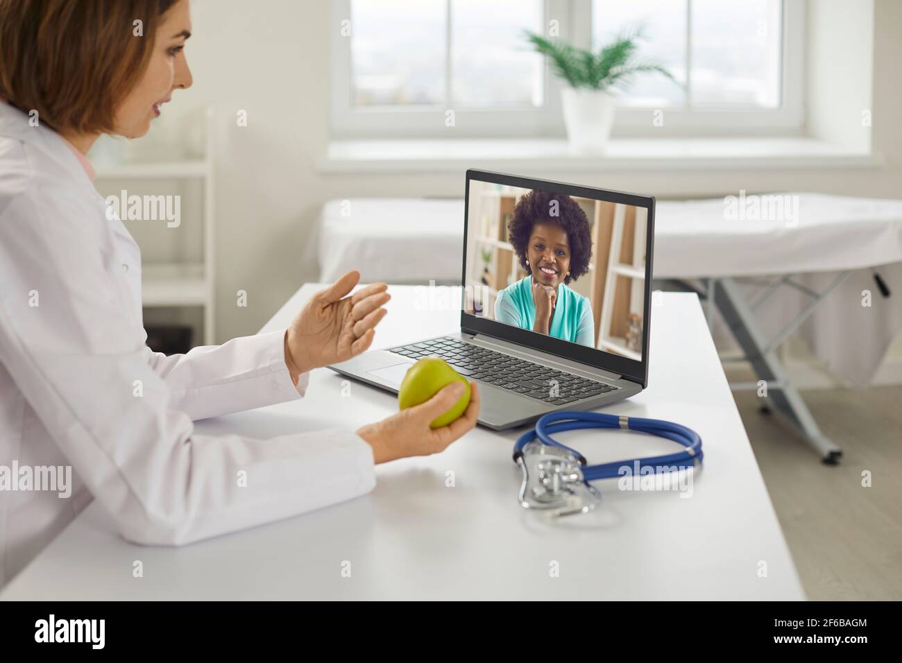 Doctor talking to her client online and giving her health and diet recommendations Stock Photo