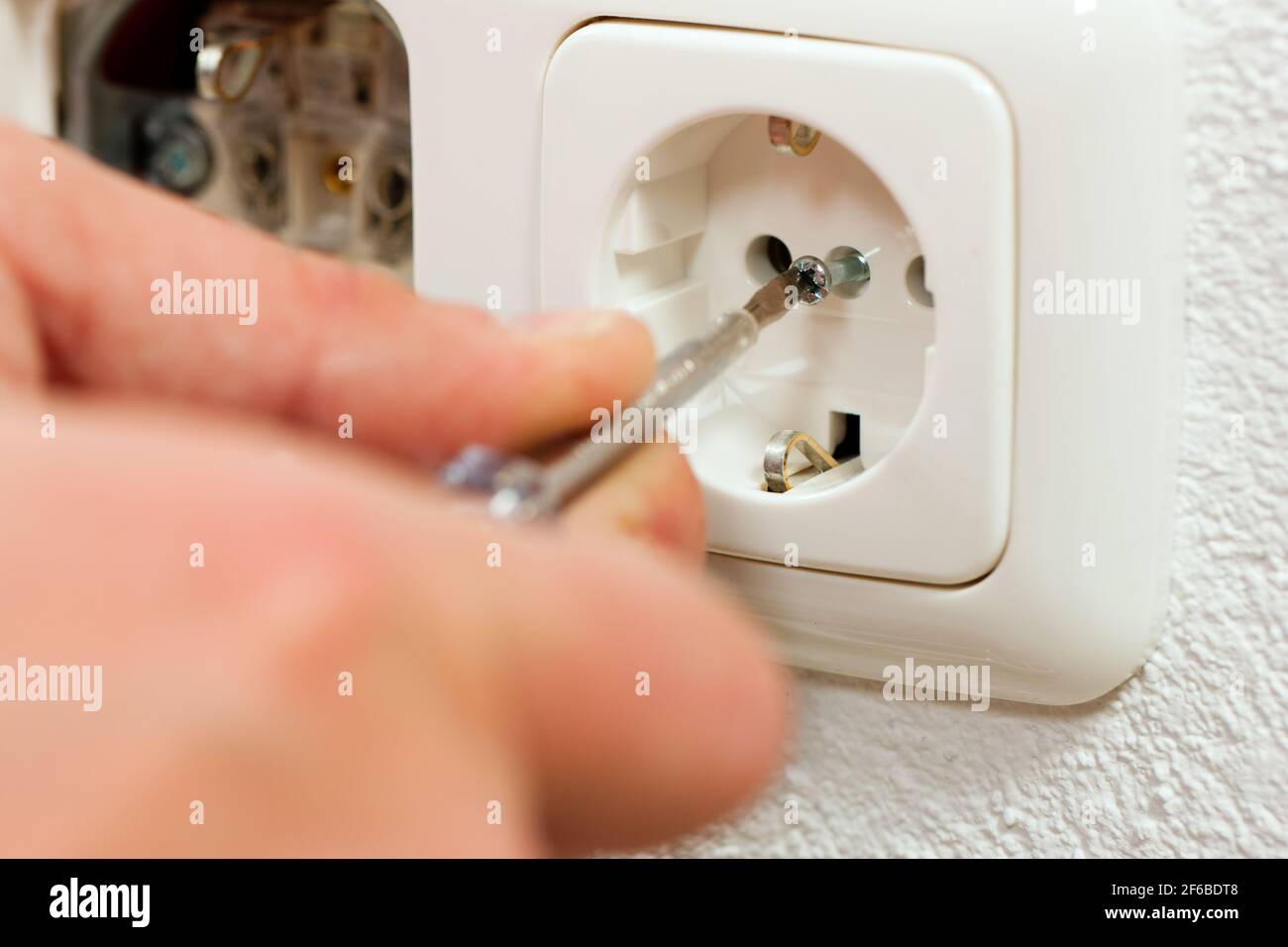 Electrician installing a power socket, close-up Stock Photo