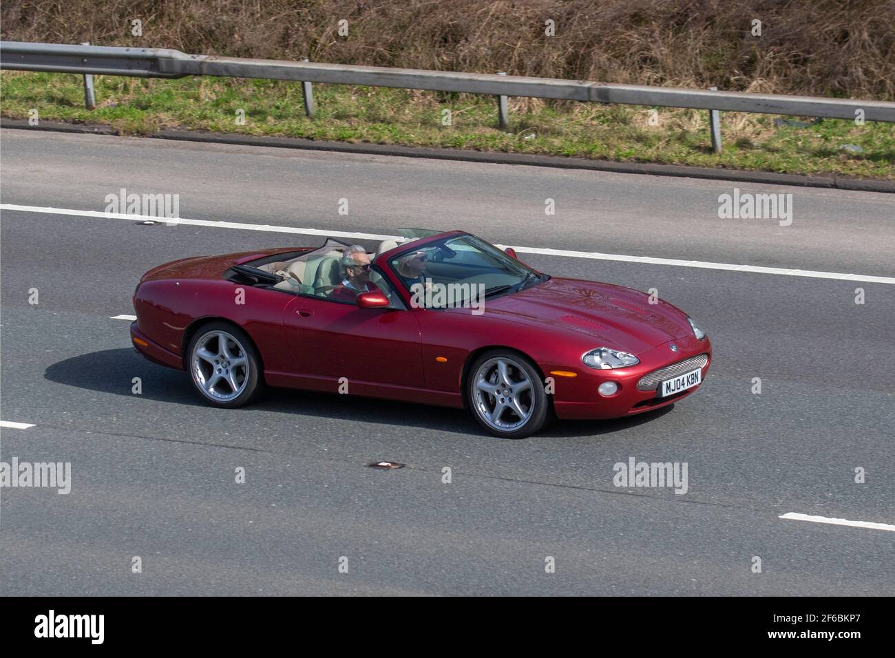 2004 04plate red Jaguar Xkr Convertible Auto 4196cc petrol cabriolet; Vehicular traffic, moving vehicles, cars, vehicle driving on UK roads, motors, motoring on the M6 highway English motorway road network Stock Photo