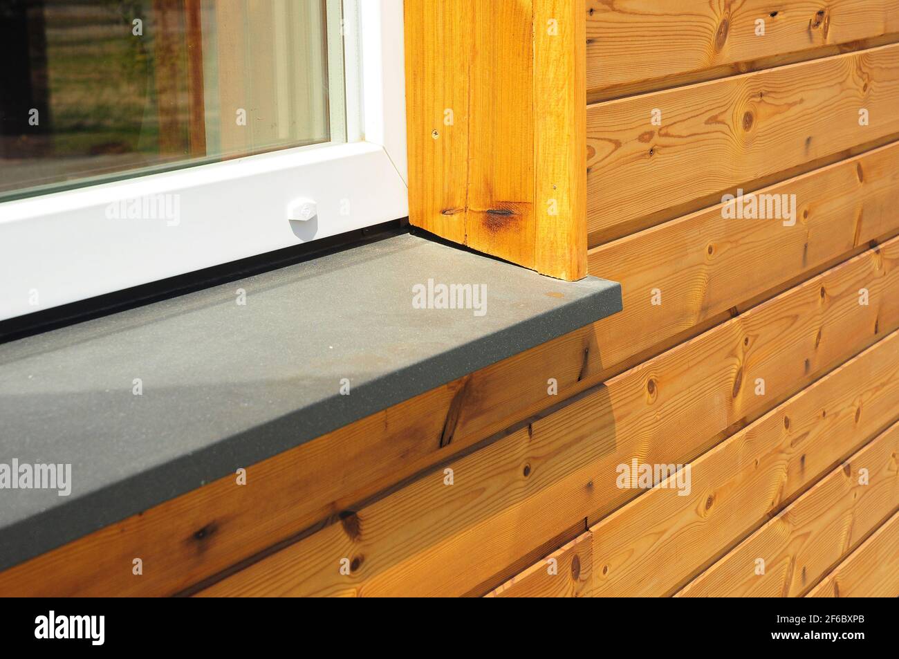 Window sill repair of a house with wooden siding, wood cladding. Stock Photo
