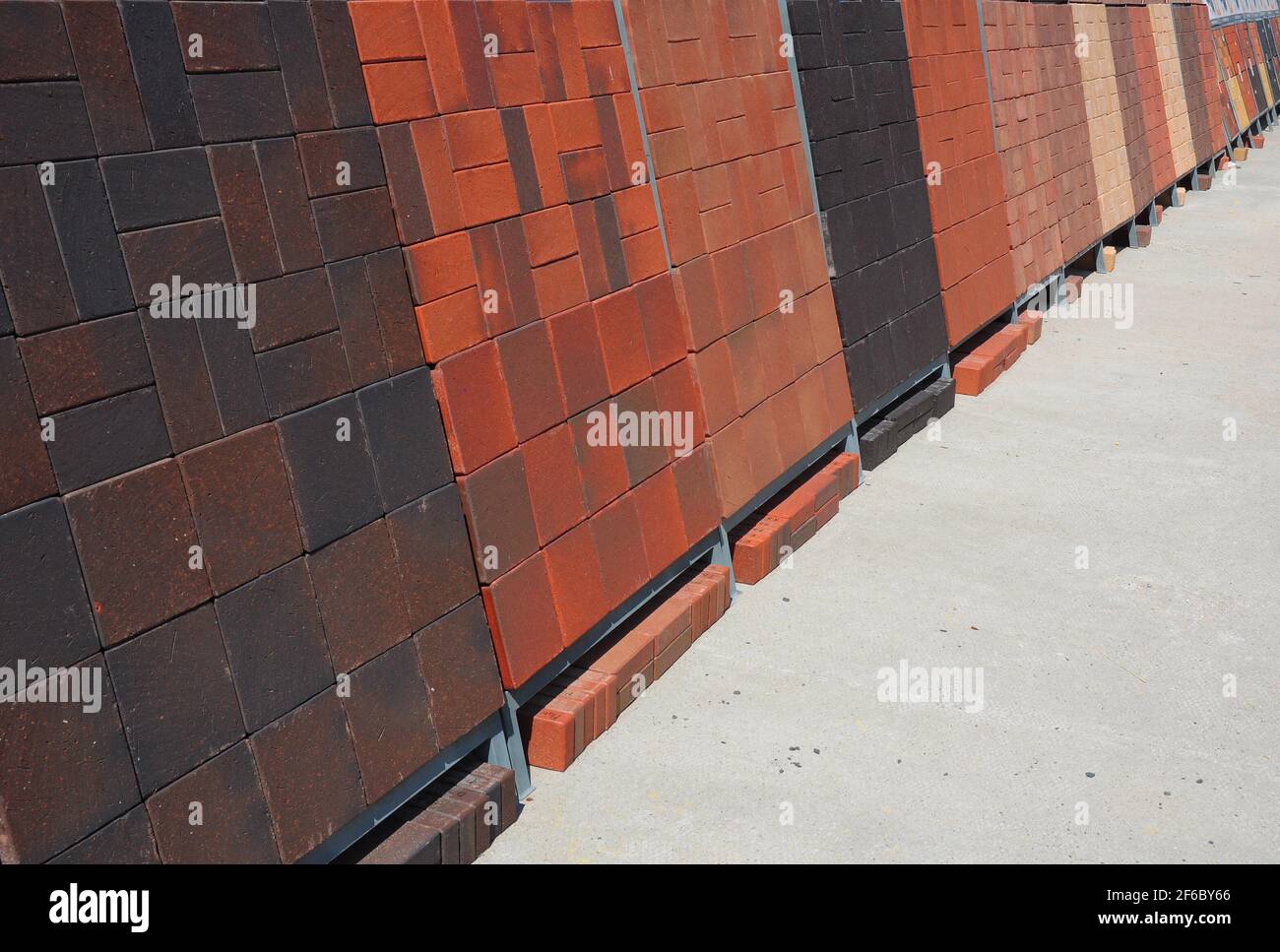 Stacks of pavers for sale. Building and construction materials, colored concrete pavers (paving stone) or patio blocks organized on pallets. Stock Photo