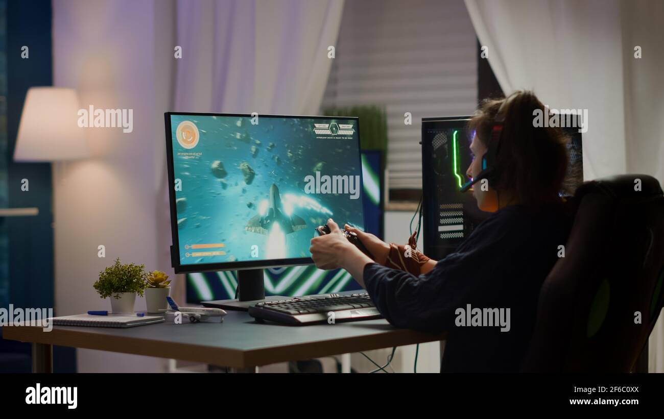 Back shot of pro gamer playing online shooter game on computer using  wireless controller. Competitive player man winning videogame tournament  use professional equipment at home gamming studio Stock Photo - Alamy