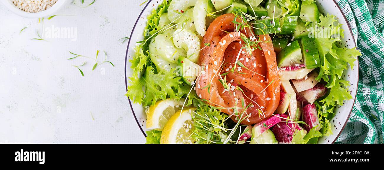 Ketogenic diet breakfast. Salt salmon salad with greens, cucumbers