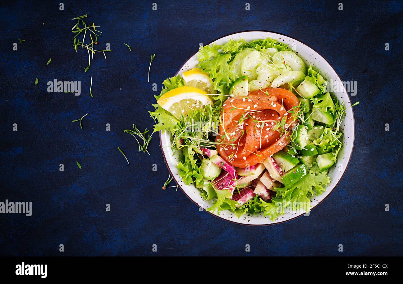 Ketogenic diet breakfast. Salt salmon salad with greens, cucumbers