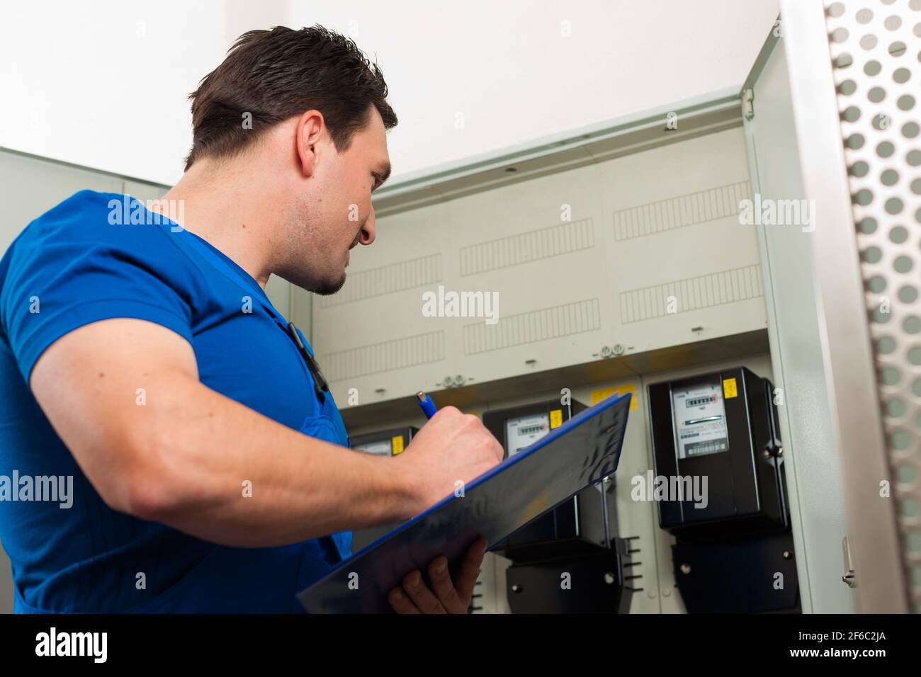 Technician reading the electricity meter to check consumption Stock
