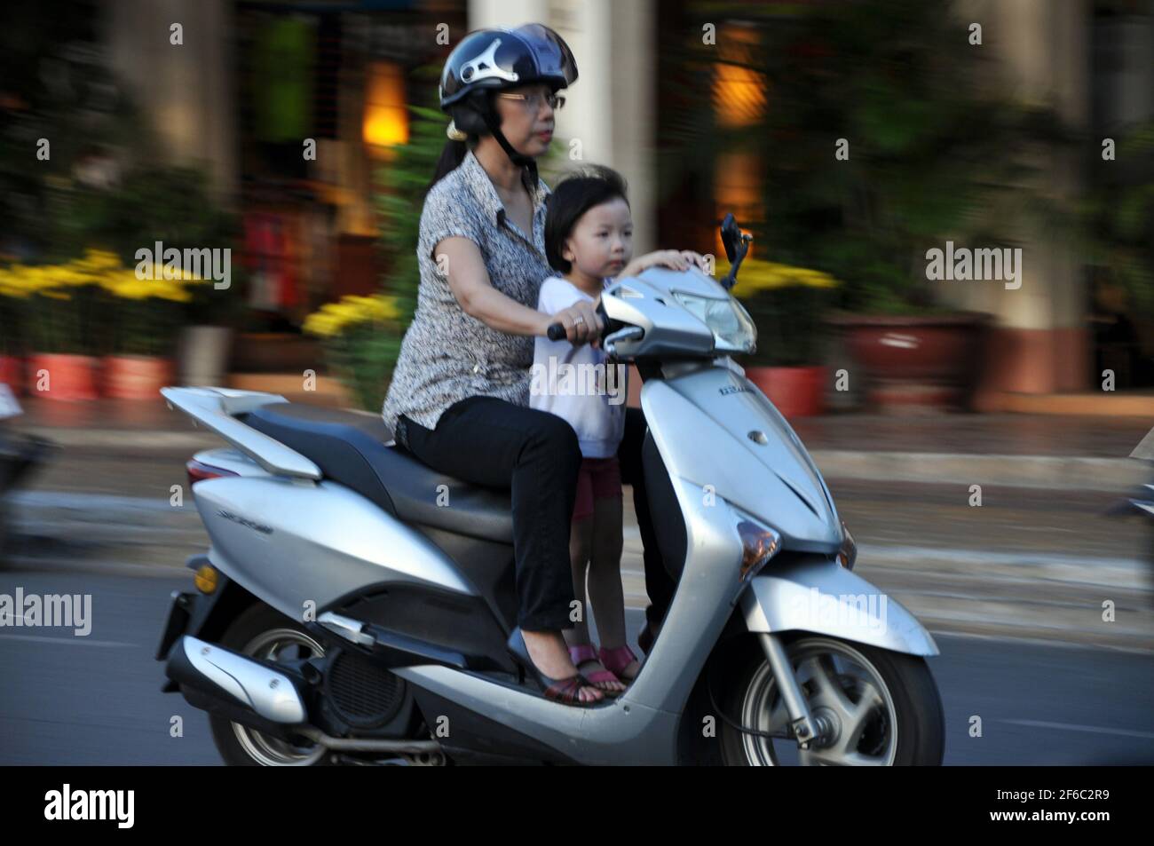 CAN THO, VIETNAM - FEBRUARY 17, 2013: Local people with motorbike driving in the biggest city of the Mekong delta, where the traffic is often congeste Stock Photo