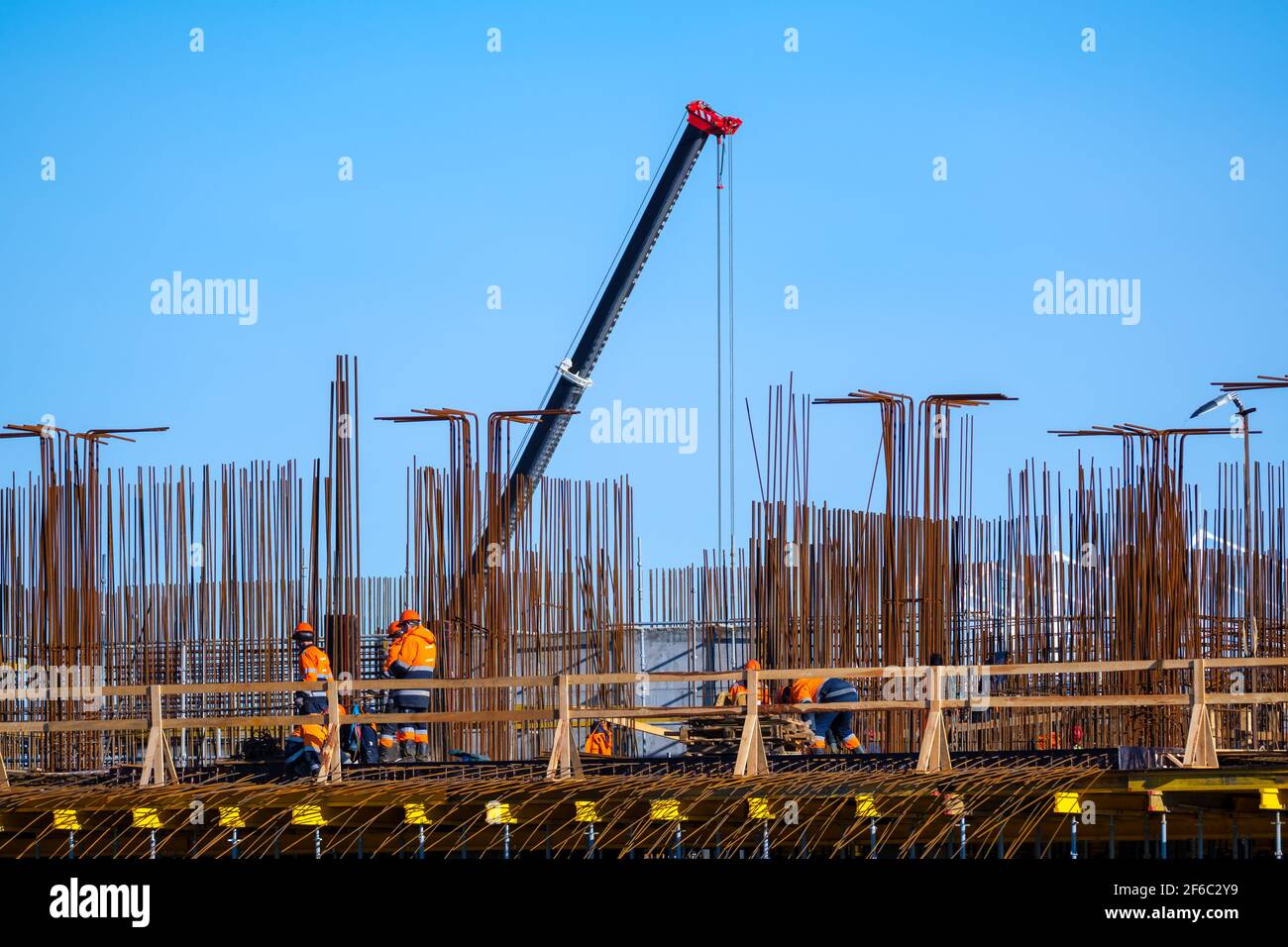 Builders walking on bridge near unfinished building Stock Photo