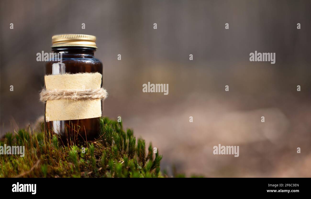 Selective focus shot of a medical bottle on green moss. Place for text Stock Photo