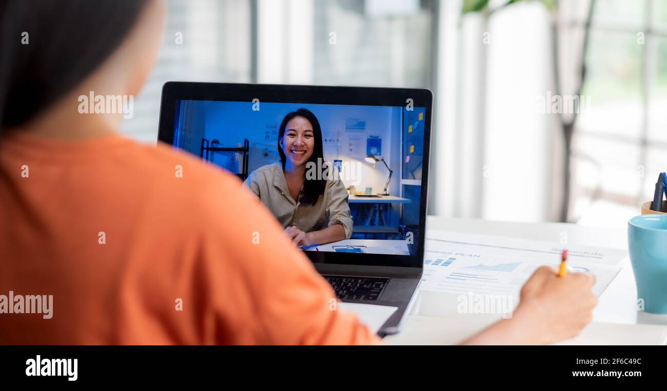 Video international conference from home.asian woman teleconference collaboration with colleagues across time zone at night while present project time Stock Photo