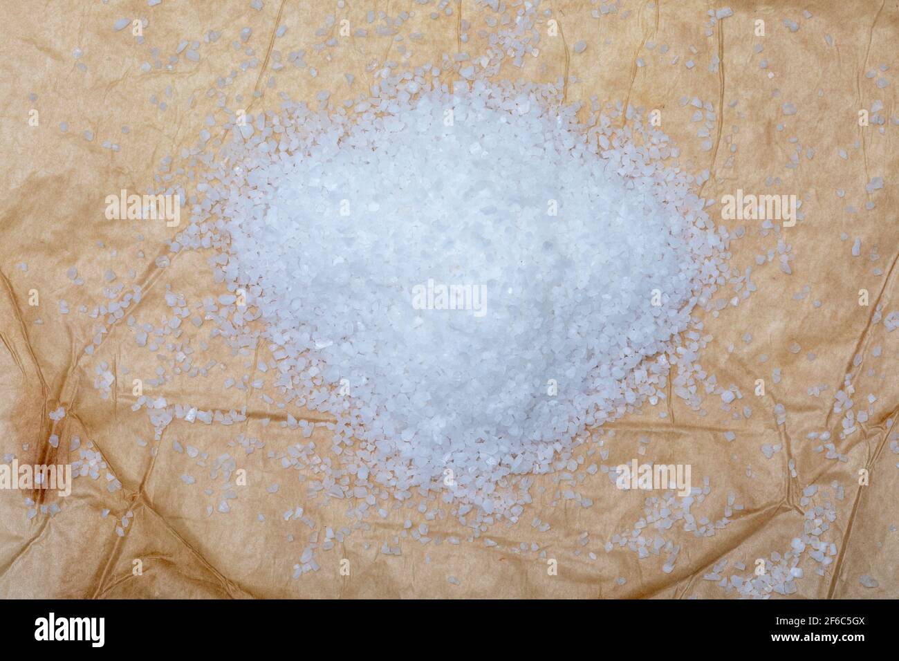 Paper texture with heap of coarse cooking salt (spices collection). On rustic background. Top view. Stock Photo