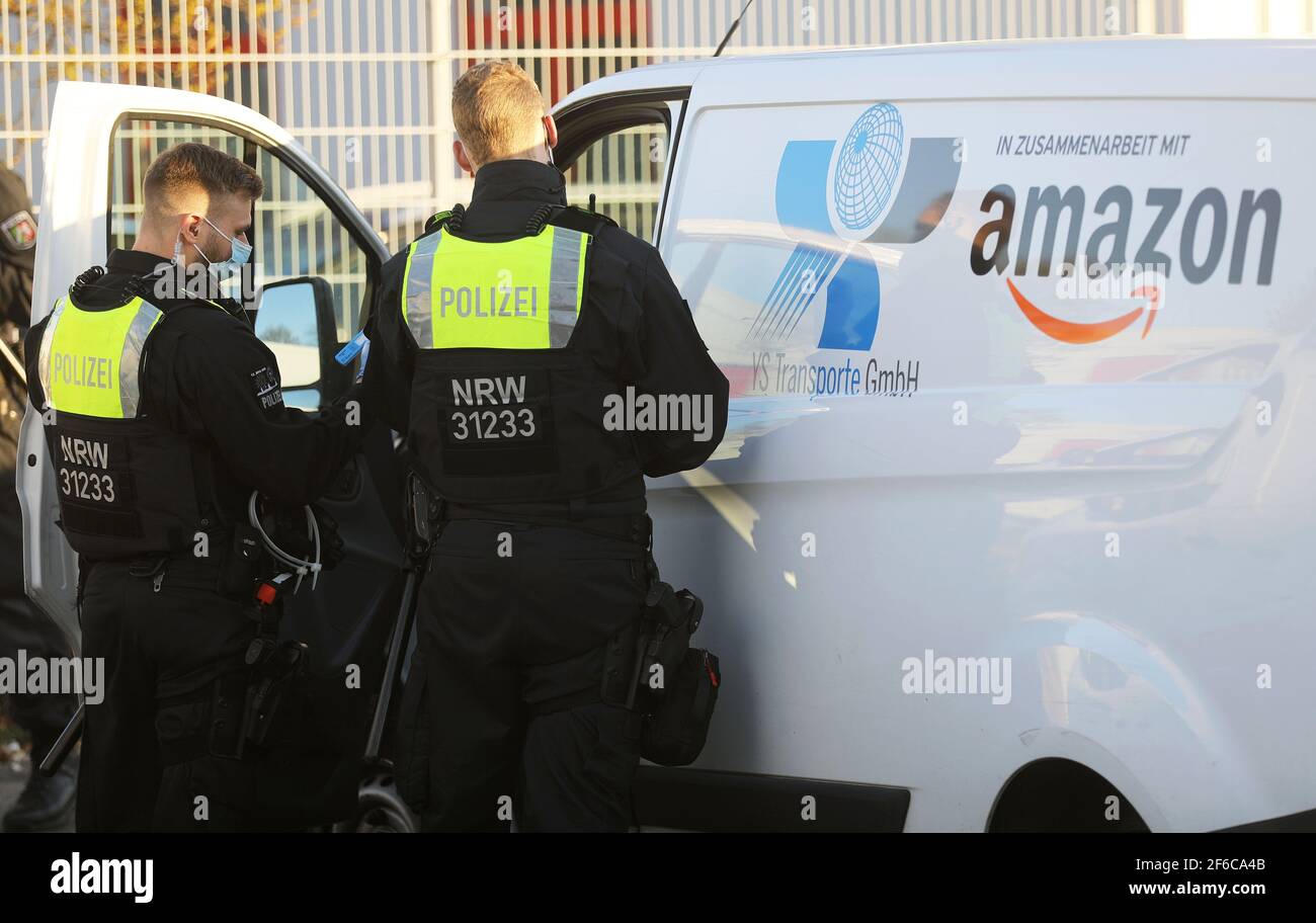 Cologne, Germany. 31st Mar, 2021. Police officers inspect an Amazon  delivery vehicle. Customs and police have inspected parcel delivery drivers  of the online retailer Amazon in Cologne. They are checking whether drivers