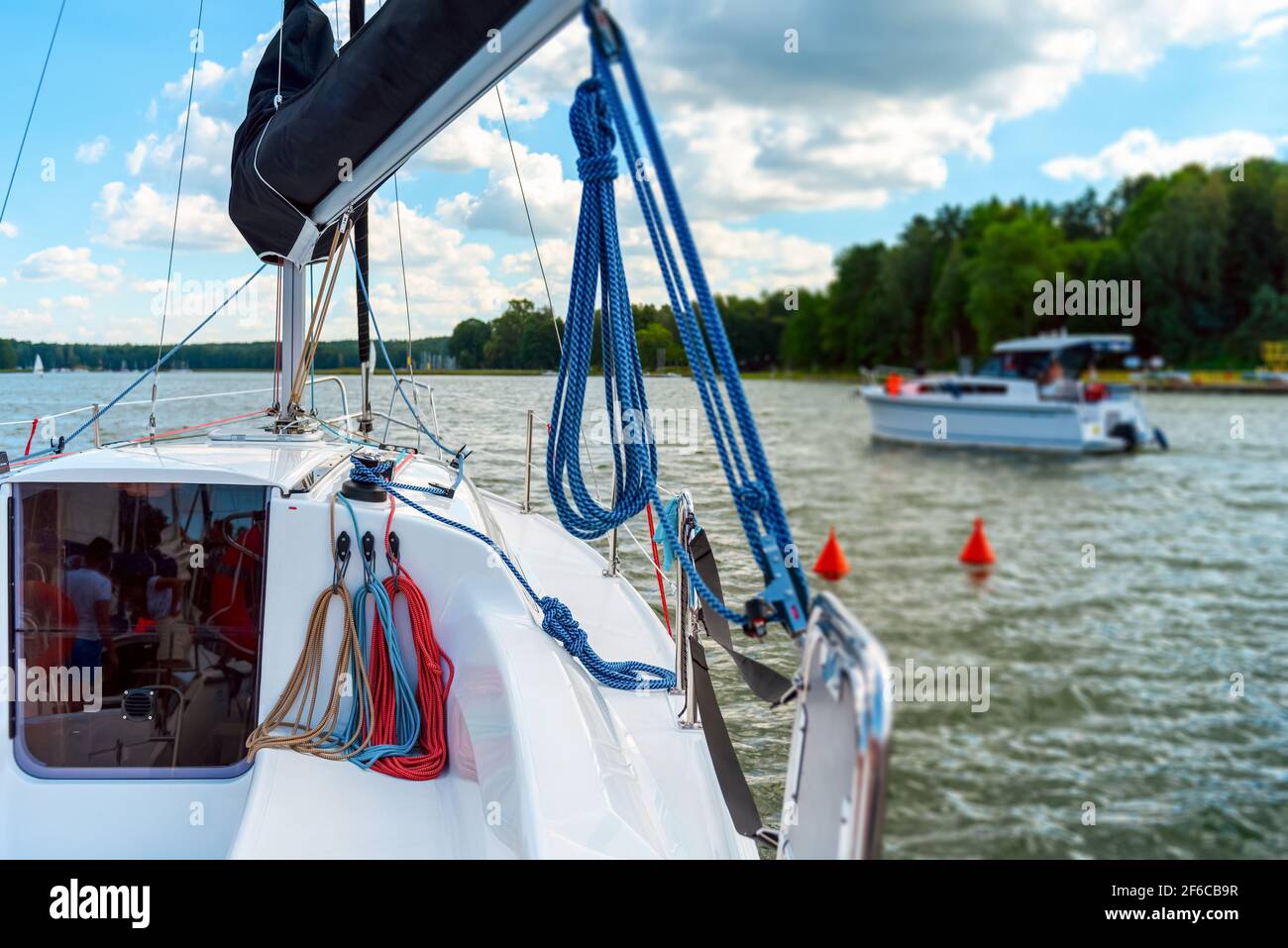 Detail of a sailboat deck with a winch and nylon ropes. Sailing yacht rigging equipment Stock Photo