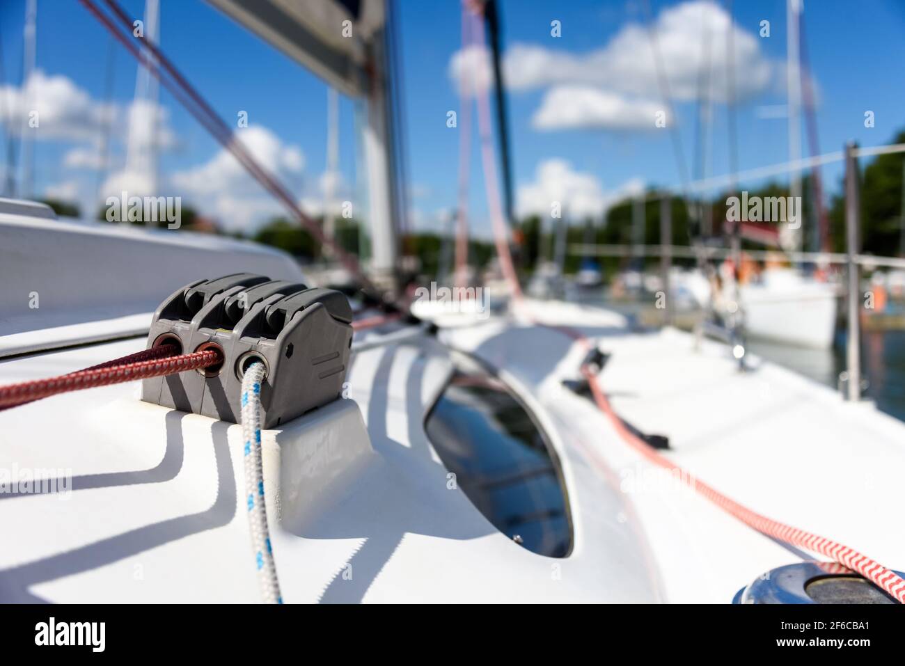 Detail of a sailboat deck with a winch and nylon ropes. Sailing yacht rigging equipment Stock Photo