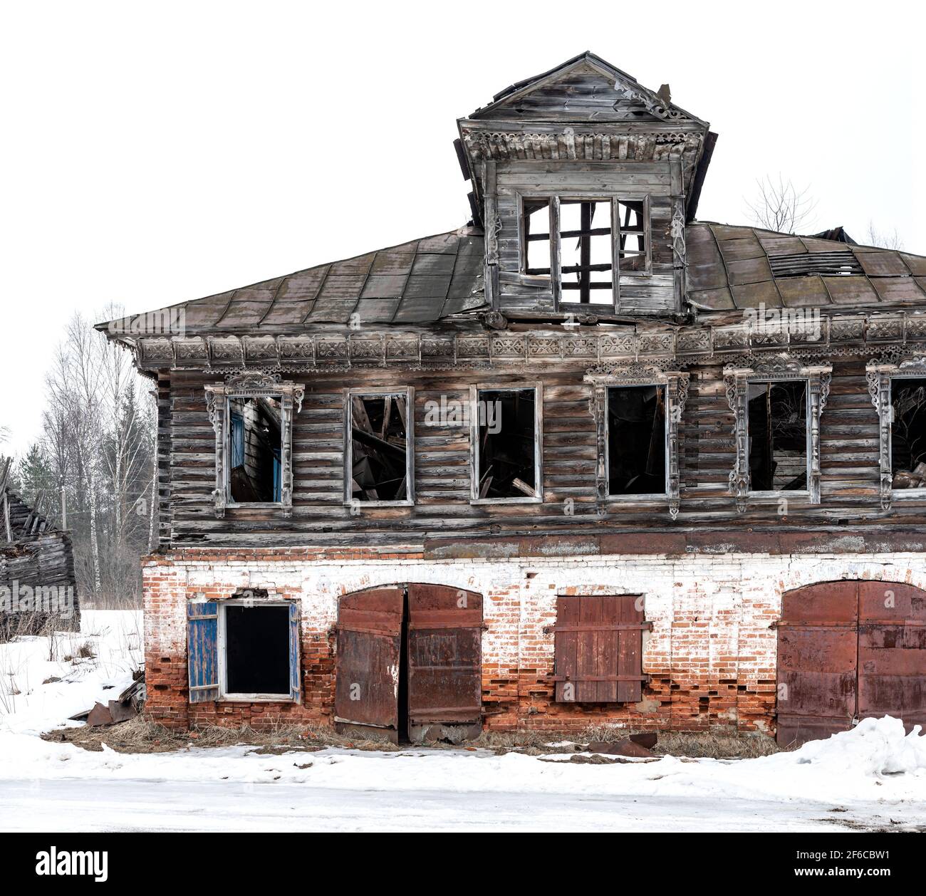 Old wooden destroyed russian house ruined made of wood and bricks metal doors Stock Photo