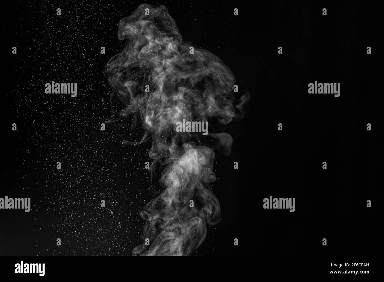 Curly white steam rising up and splashing water scattering in different directions isolated on a black background. Evaporation of liquid and condensat Stock Photo