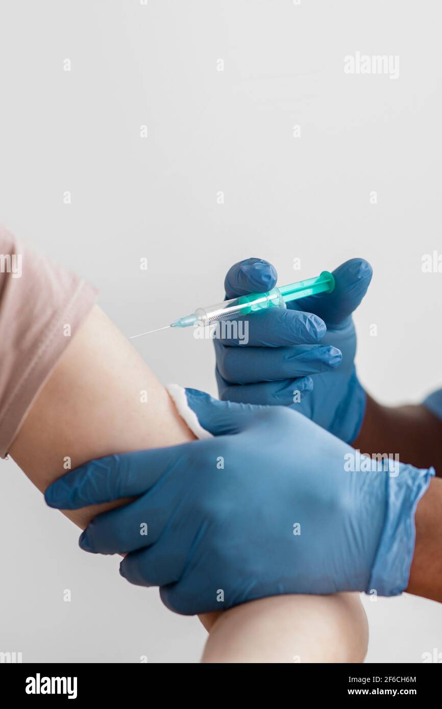 Doctor giving patient needle hi-res stock photography and images - Alamy