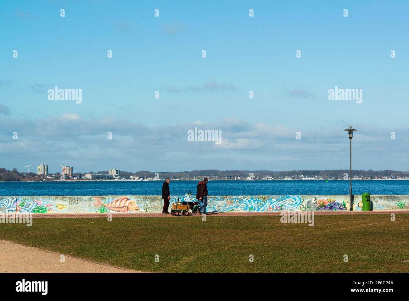 Eine Familie beim Spaziergang am Strand vom Ostseebad Laboe an der Kieler Förde Stock Photo