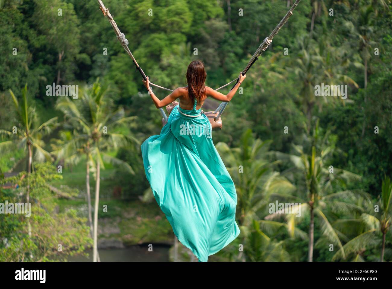 Woman in long turquoise dress swinging in the jungle, Bali Stock Photo - Alamy Woman in long turquoise dress swinging in the jungle, Bali Stock Photo - Alamy
