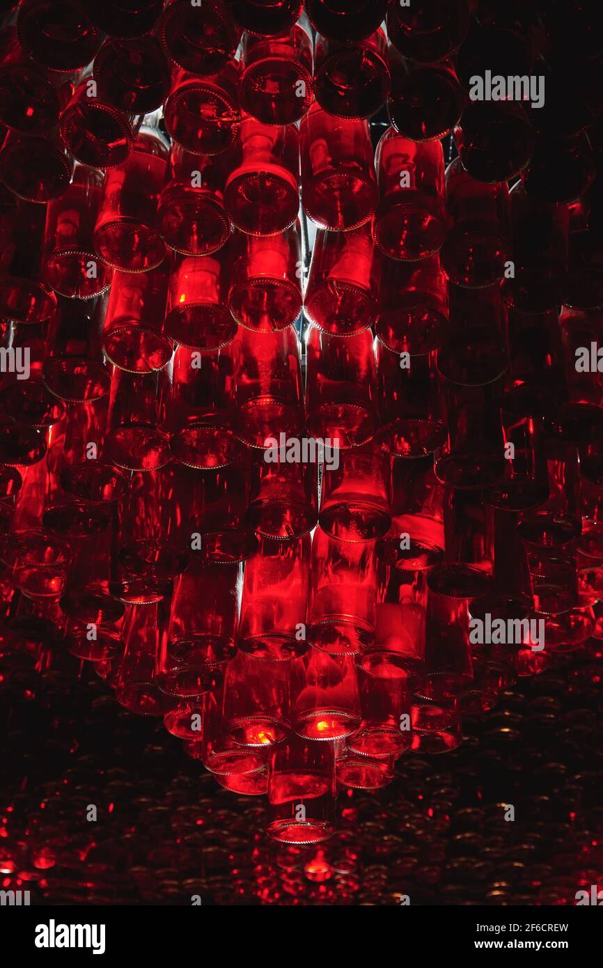 Ceiling of bar made from many bottles with red liquid. Atmosphere bar with low light. Alcohol drinks concept photo. Vertical photo. Stock Photo