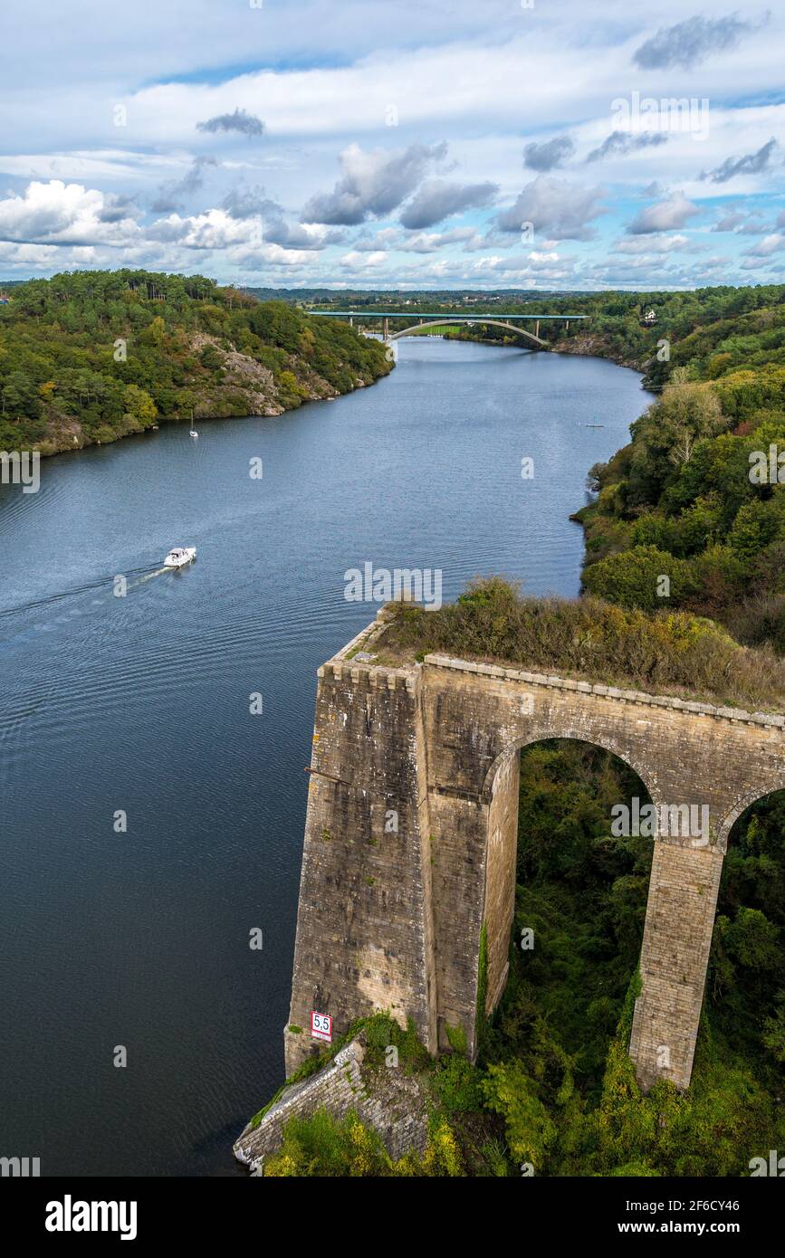 The old Roche Bernard bridge on Vilaine river with green banks Stock Photo