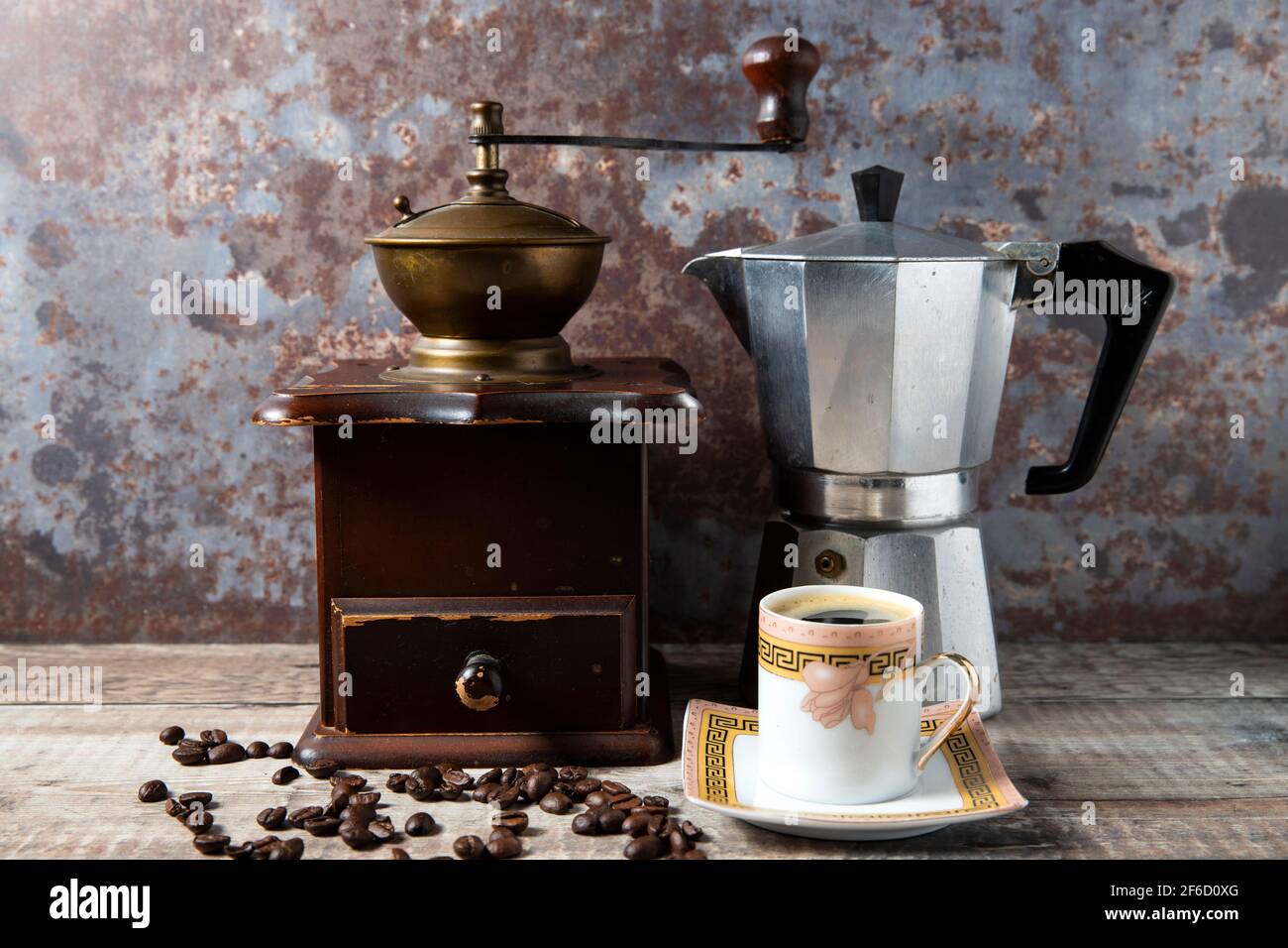 Simple still life of a manual coffee bean grinder, coffee pot and
