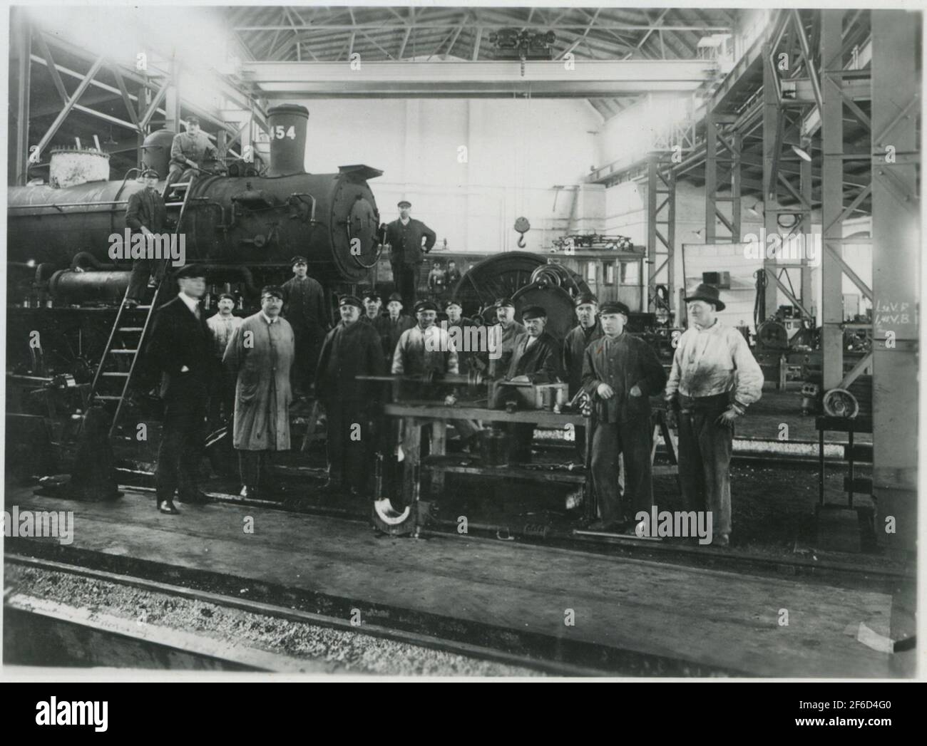 Staff at the locomotive workshop at Sävenäs Rangerbangård. The state railways, SJ E2 1454. The steam locator is provided with feed water preheater. Stock Photo