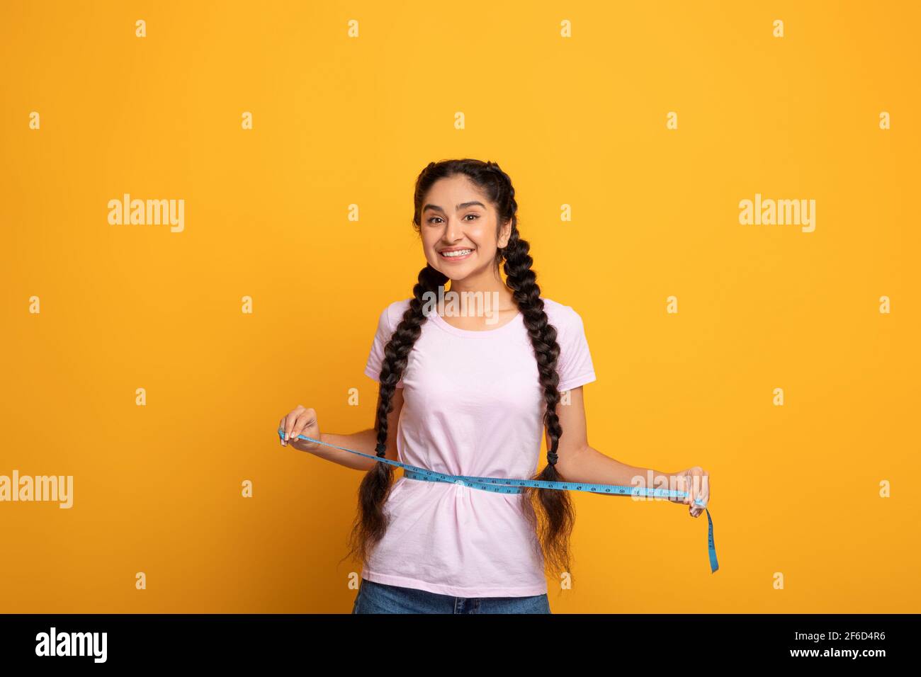 Happy Indian Woman Measuring Waist With Tape. Slimming Concept Stock Photo