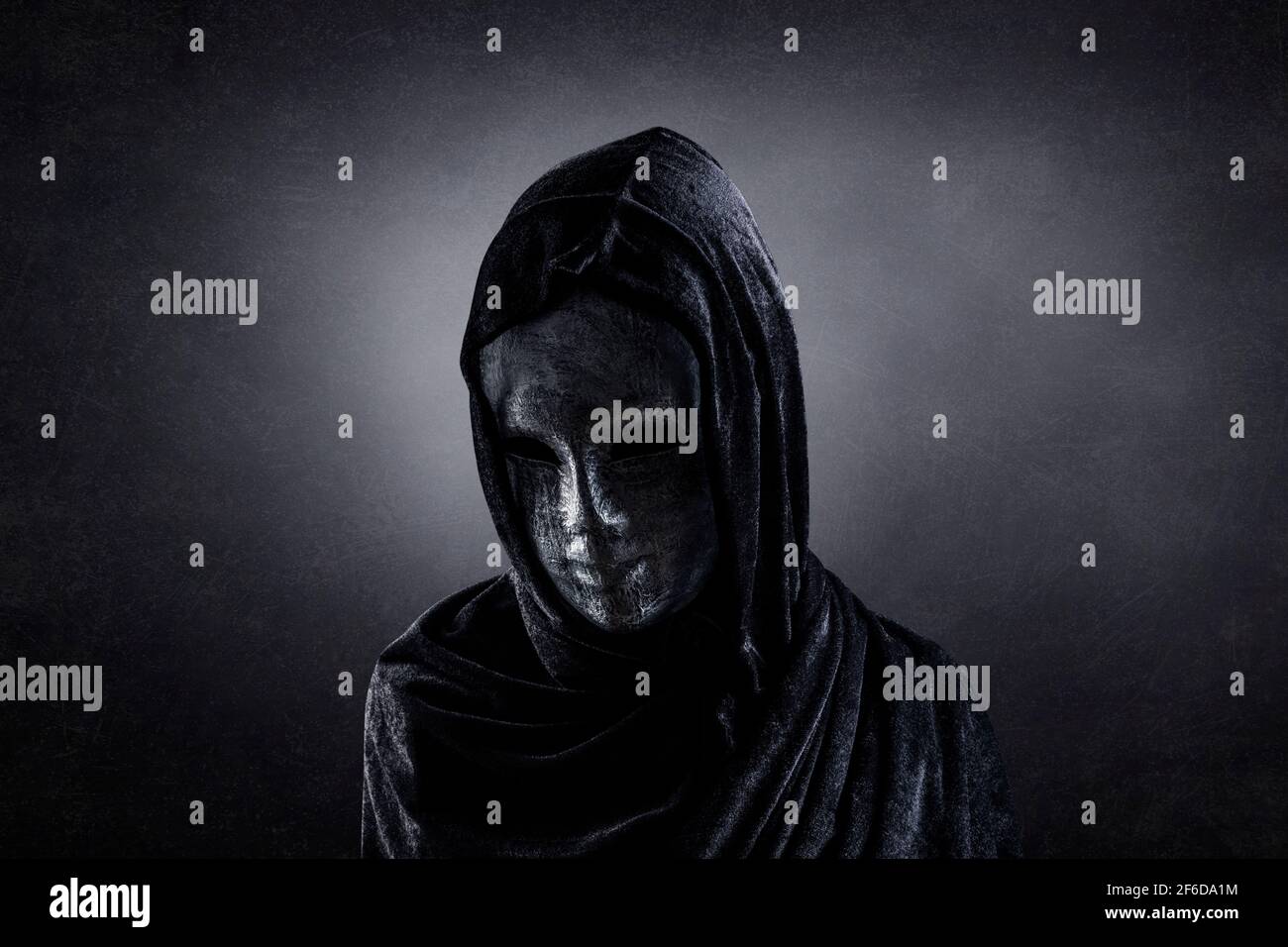 Scary figure with hooded cape in the dark Stock Photo - Alamy