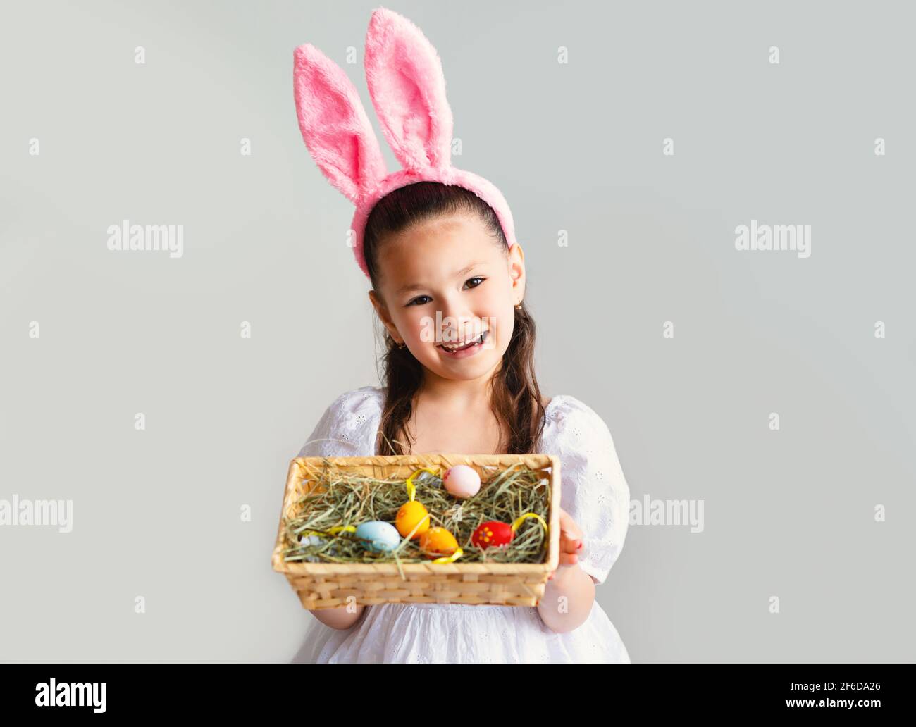 Little Girl Wearing Easter Bunny Ears Posing On Gray Background St pic