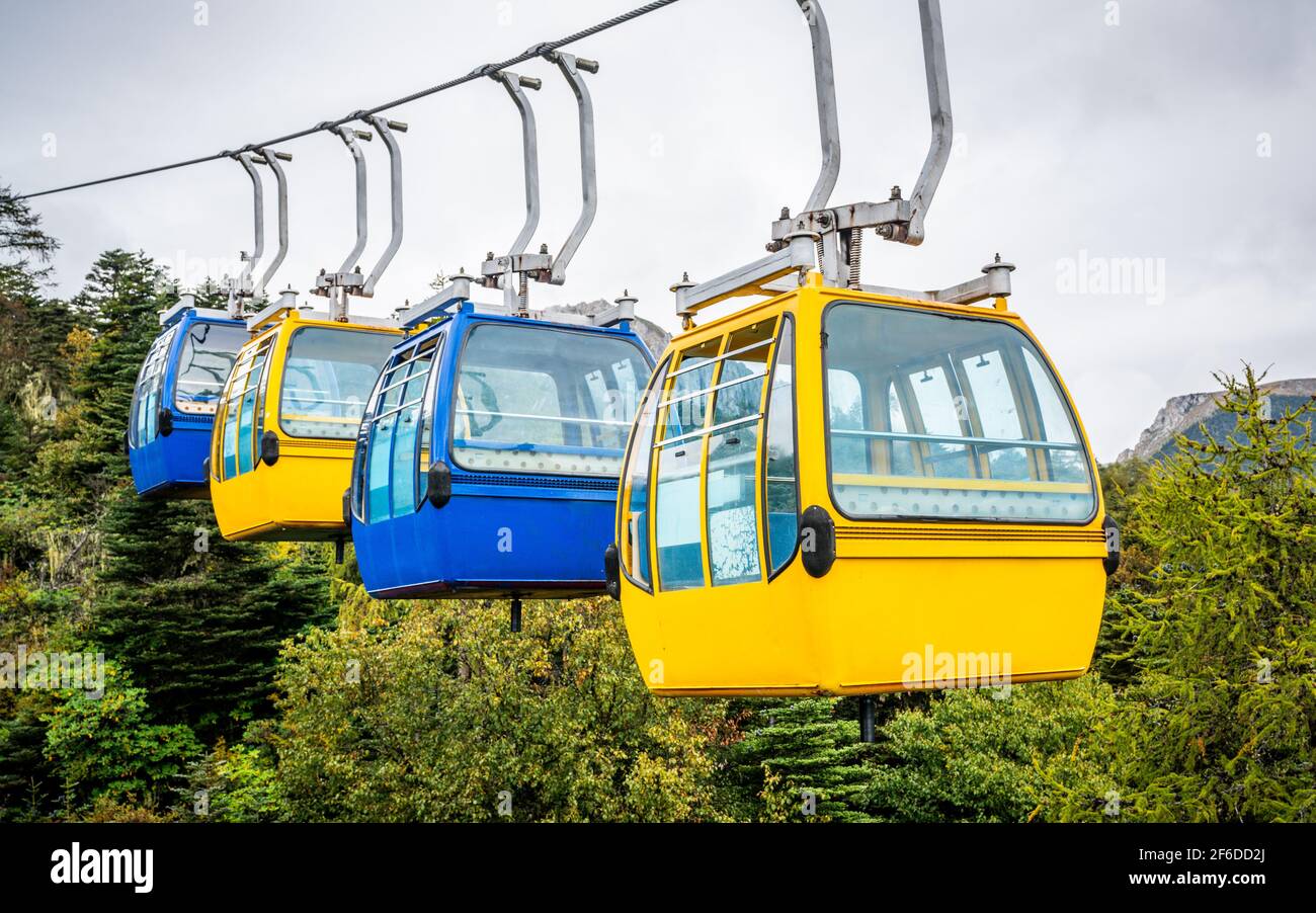 View of ropeway with four blue and yellow fixed grip cable car Stock