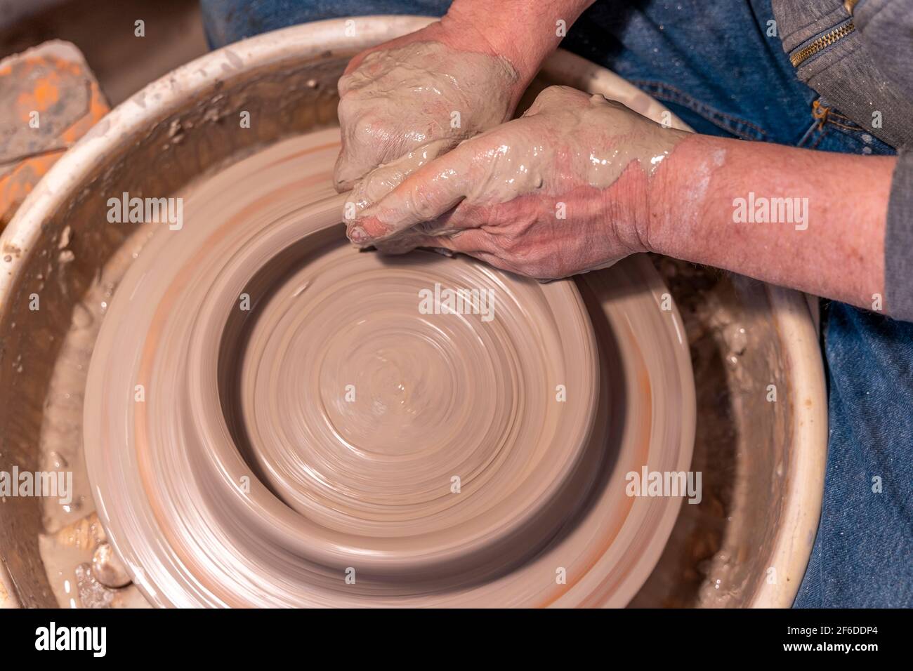 close-up on male hands working on a potters wheel to make a bowl Stock ...