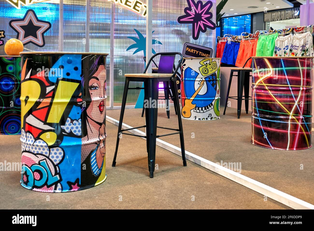 Comic book and pop art furnishing featuring colourful oil drums in a teen cafe environment Stock Photo