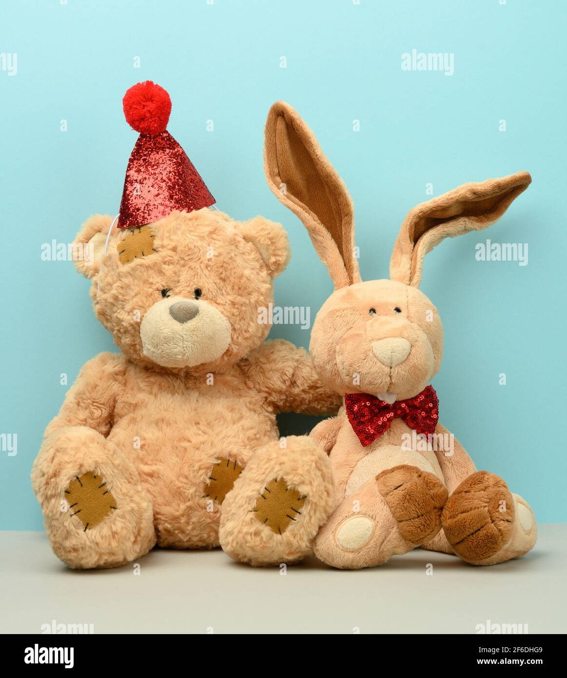 Teddy Bear In A Cap And A Cute Teddy Hare With Long Ears A Red Butterfly Is Tied Around The Neck Blue Background Stock Photo Alamy
